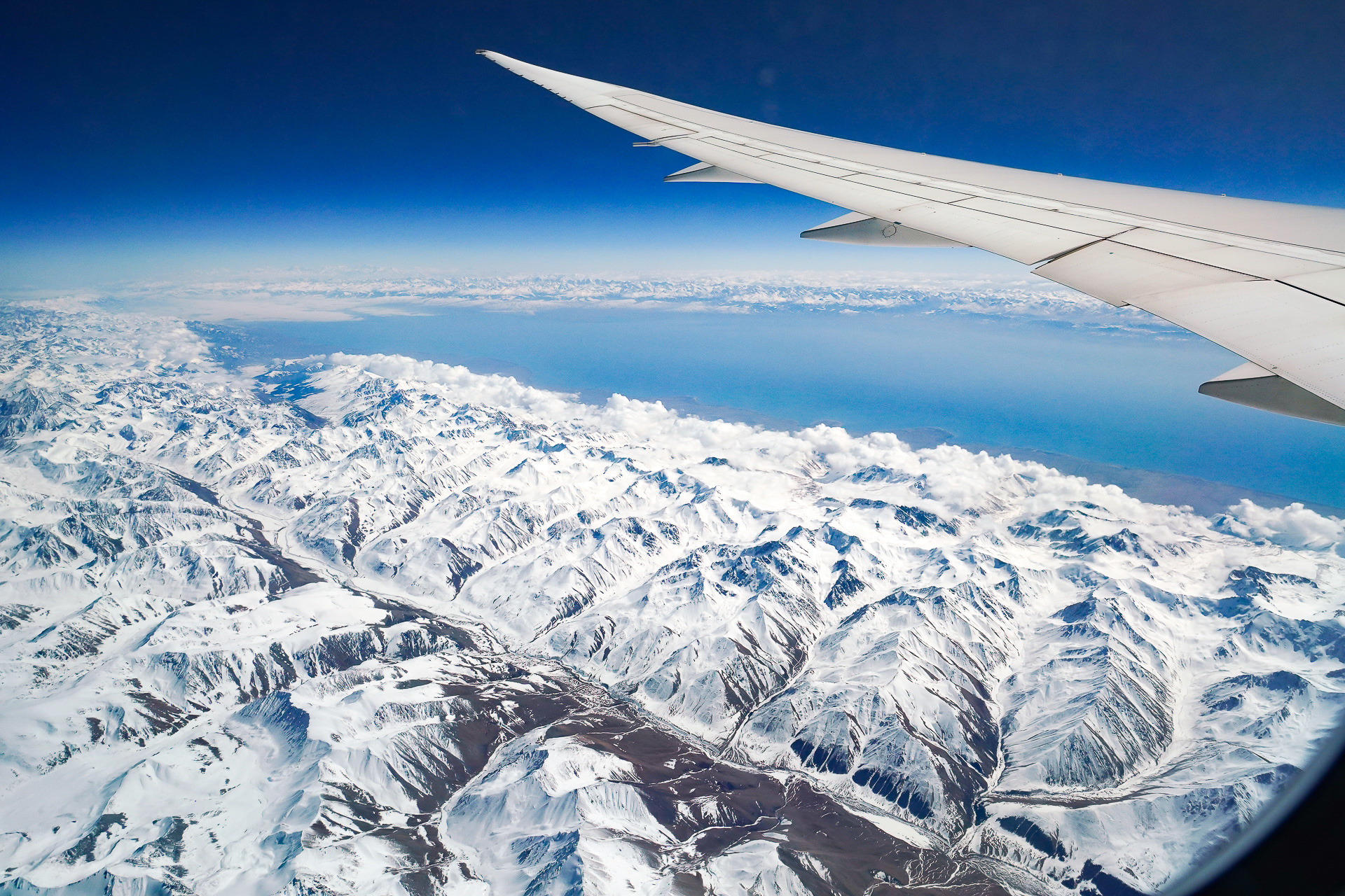 ウズベキスタンに向かう機内から見た中央アジアの山岳地帯。イシク・クル湖が見える