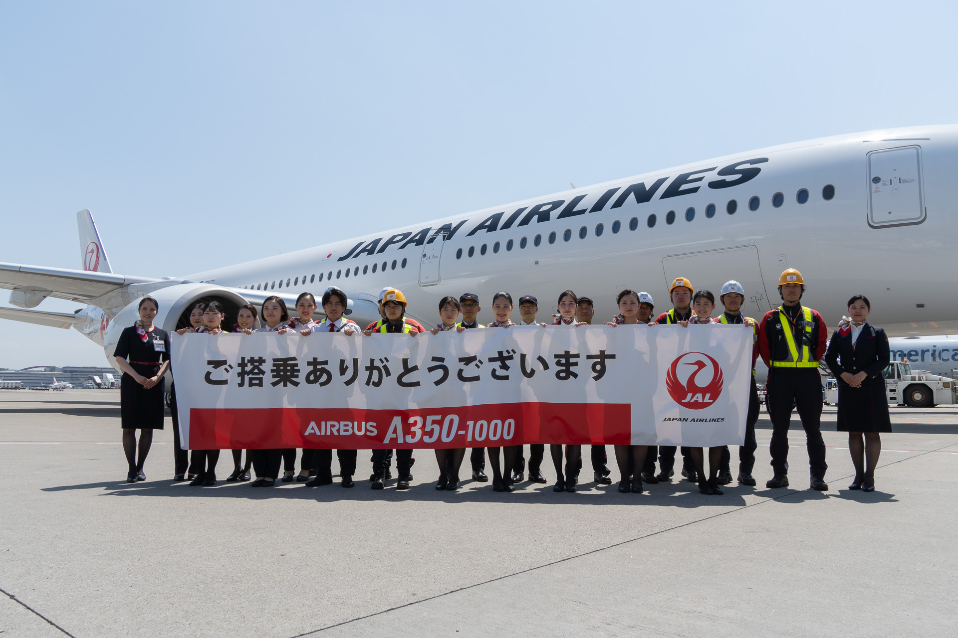 スタッフが横断幕とともにA350-1000の投入初便を見送った