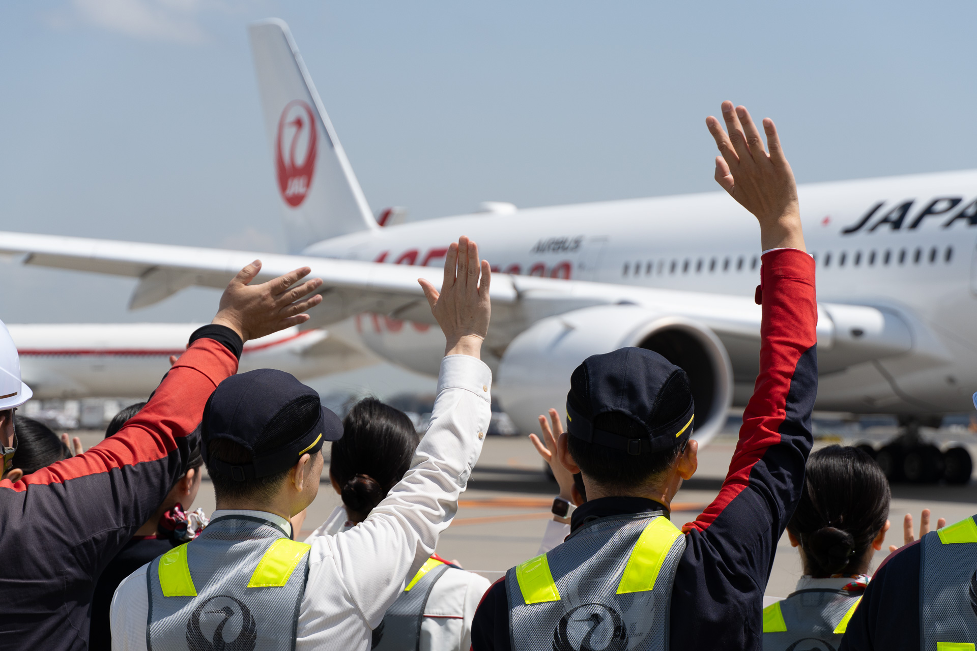 スタッフが横断幕とともにA350-1000の投入初便を見送った