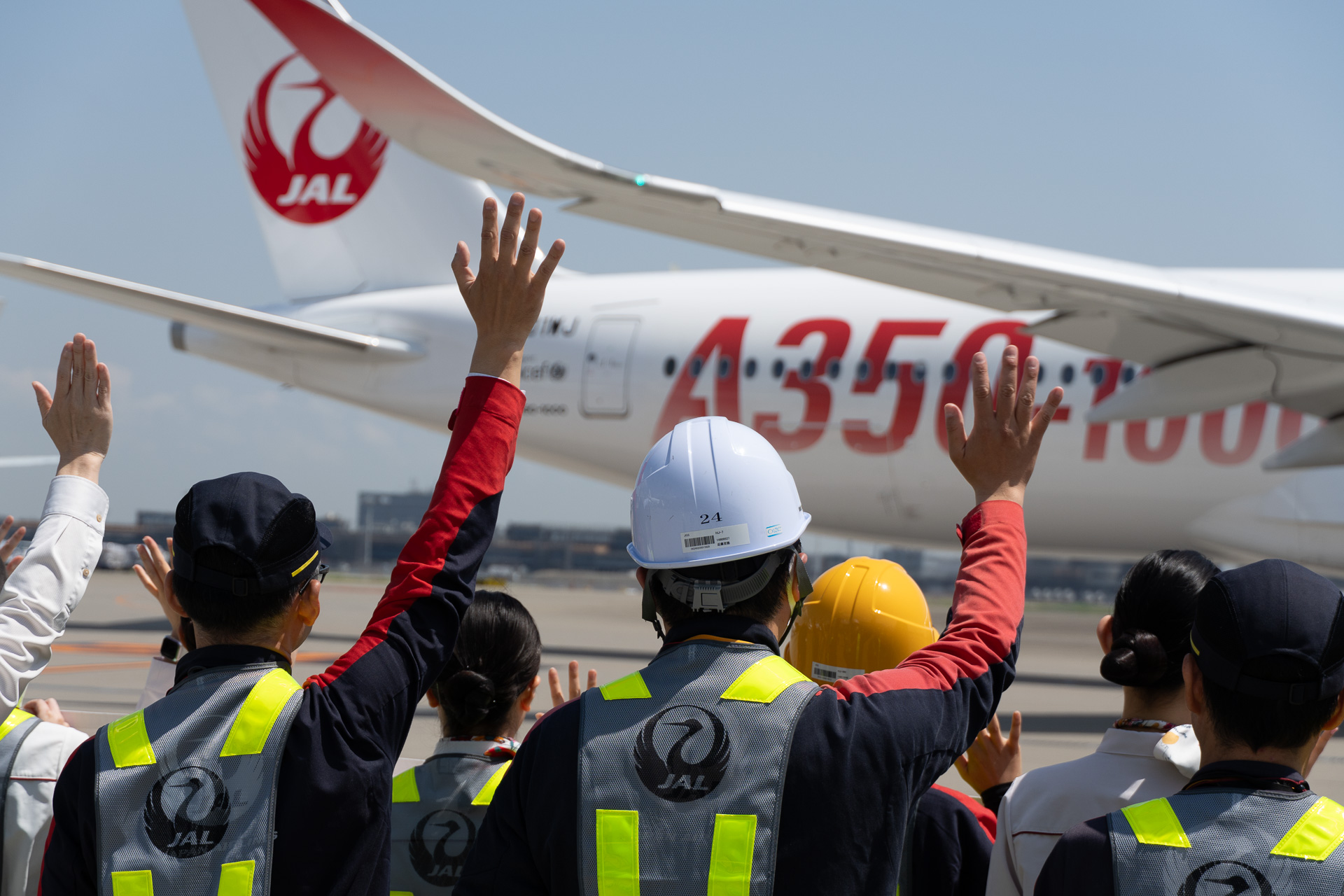 スタッフが横断幕とともにA350-1000の投入初便を見送った