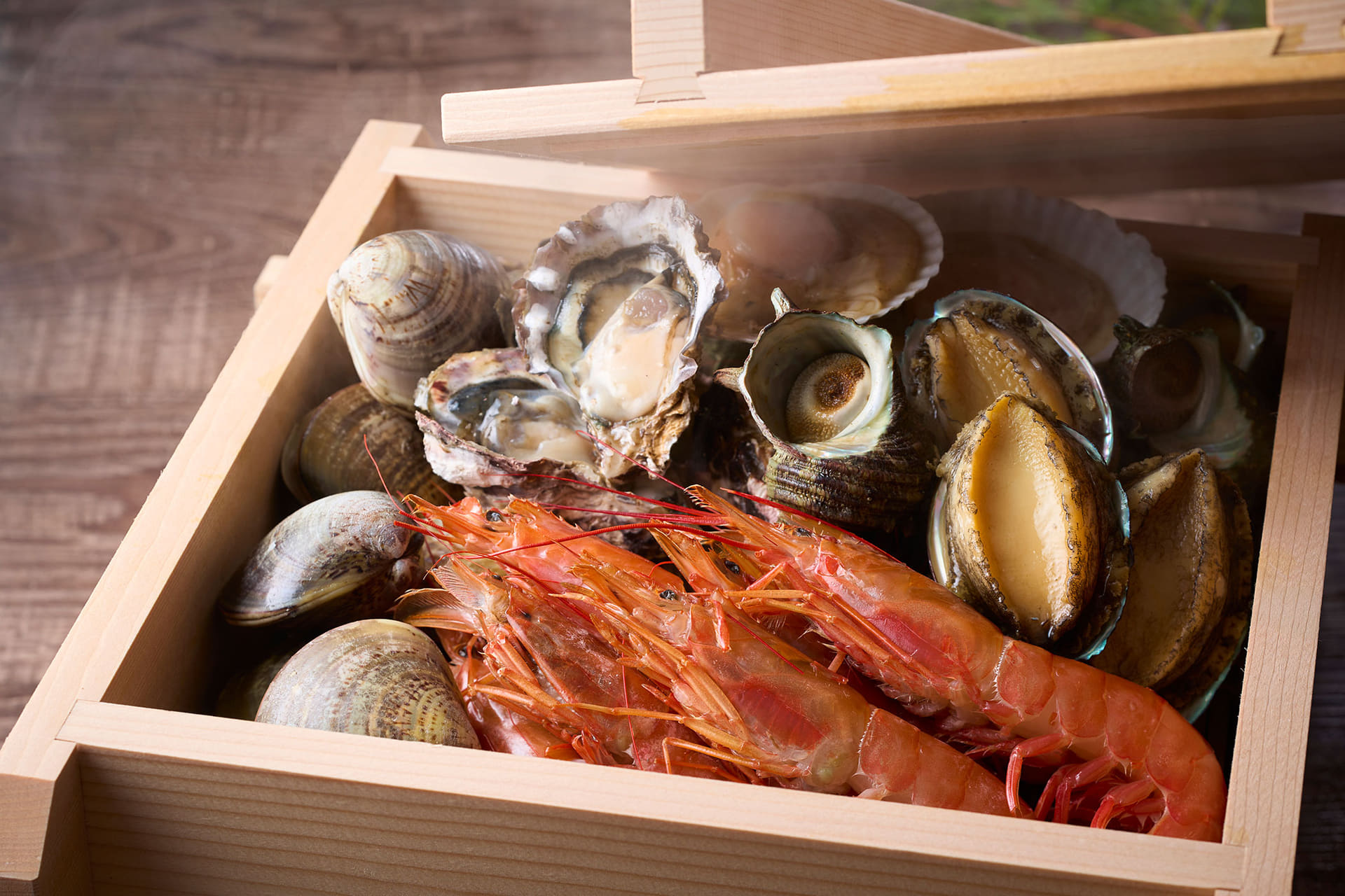 ホタテやアワビ、サザエ、牡蠣などの海鮮浜蒸し。席で蒸したてを味わえる