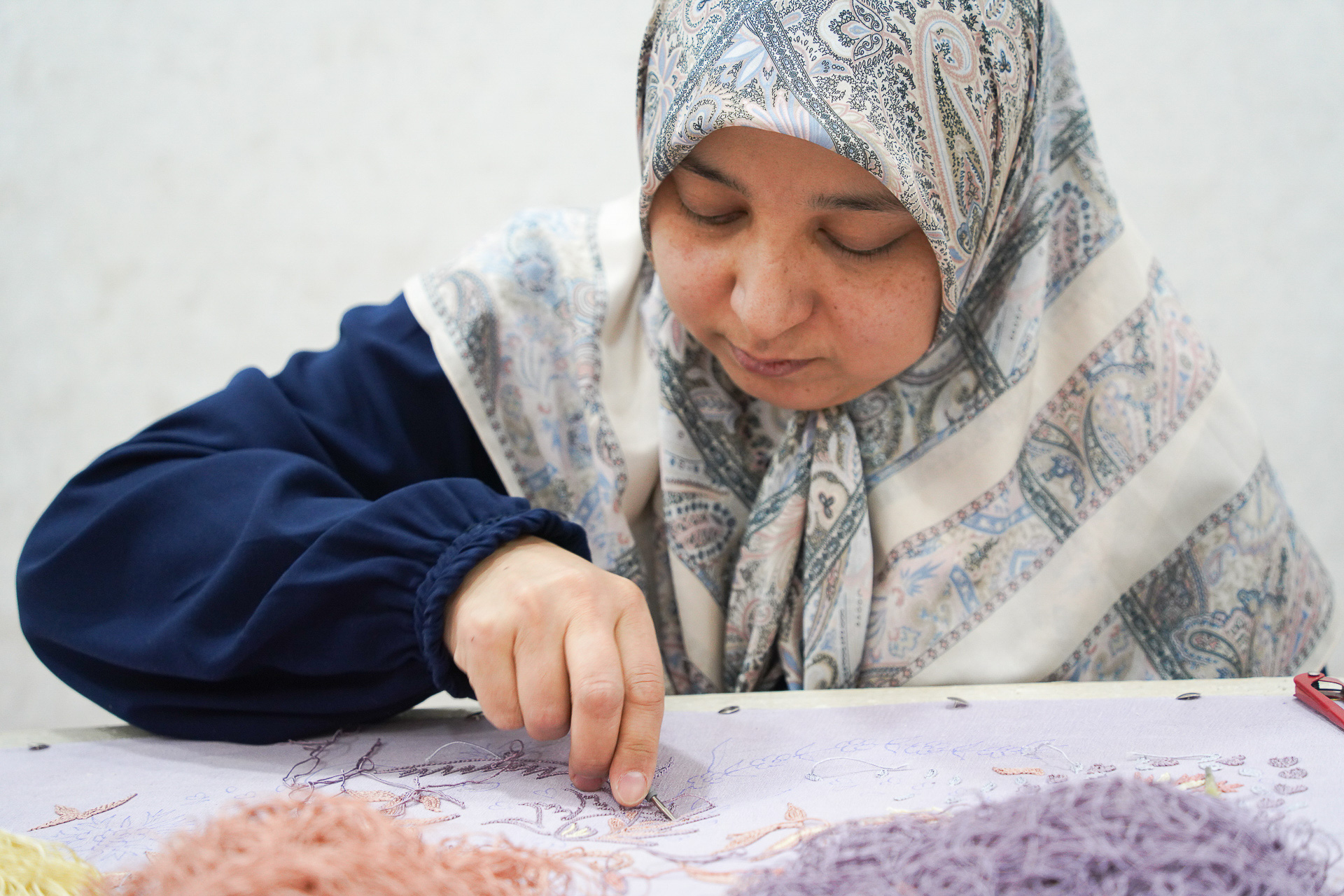 女性たちが手縫いの刺繍で仕上げている