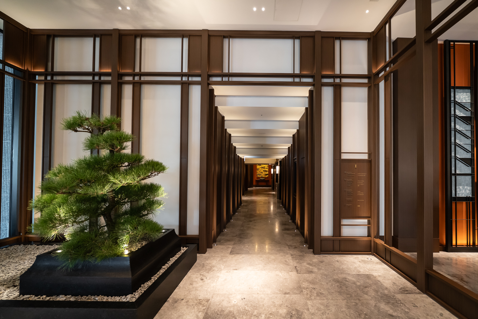グランドエントランス横にエレベーターホールの入口がある。立派な盆栽が飾られている