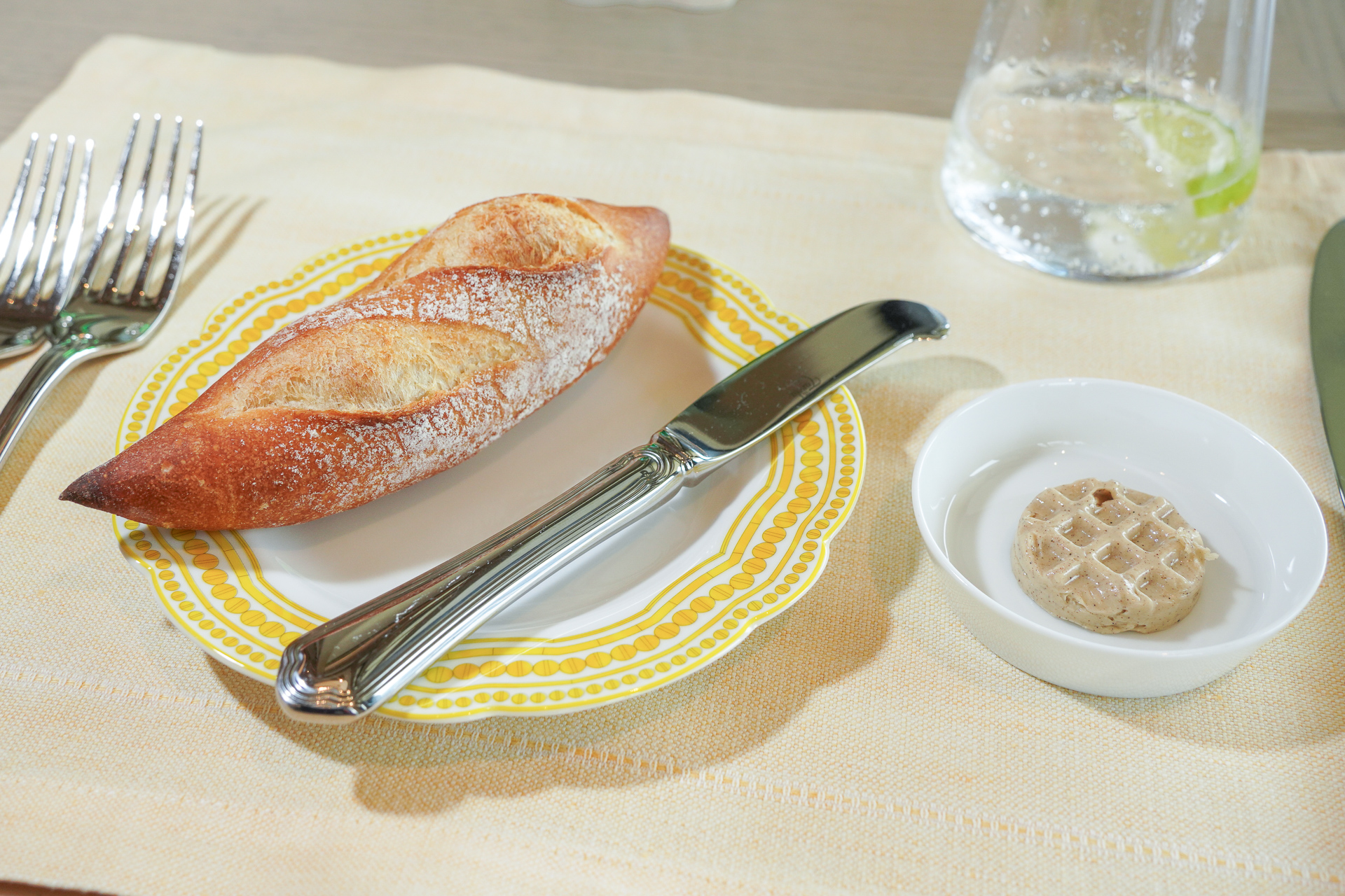 試食した「グランドオープニングセレブレーションランチ」のコースは、まず自家製バゲットから。水は、ペリエにライム入りを選択