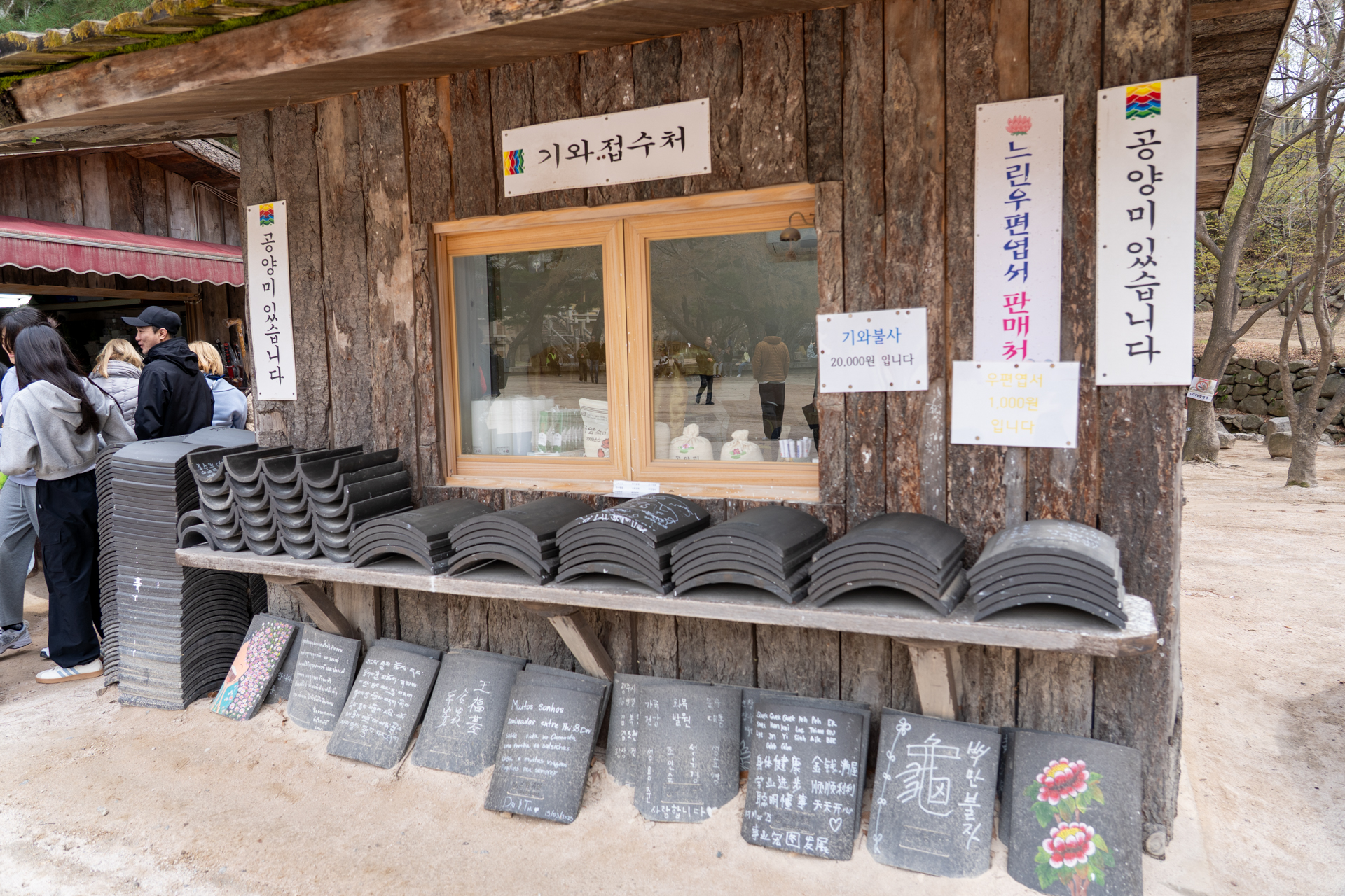 瓦に願い事を書いて寄進する風習がある韓国のお寺。土産物店も大繁盛
