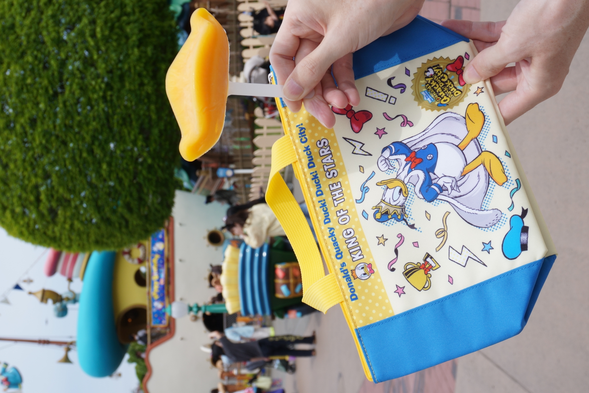 トゥモローランド・テラスで販売中のスーベニアランチケース（左）、ドナルドダックアイス マンゴー（右）