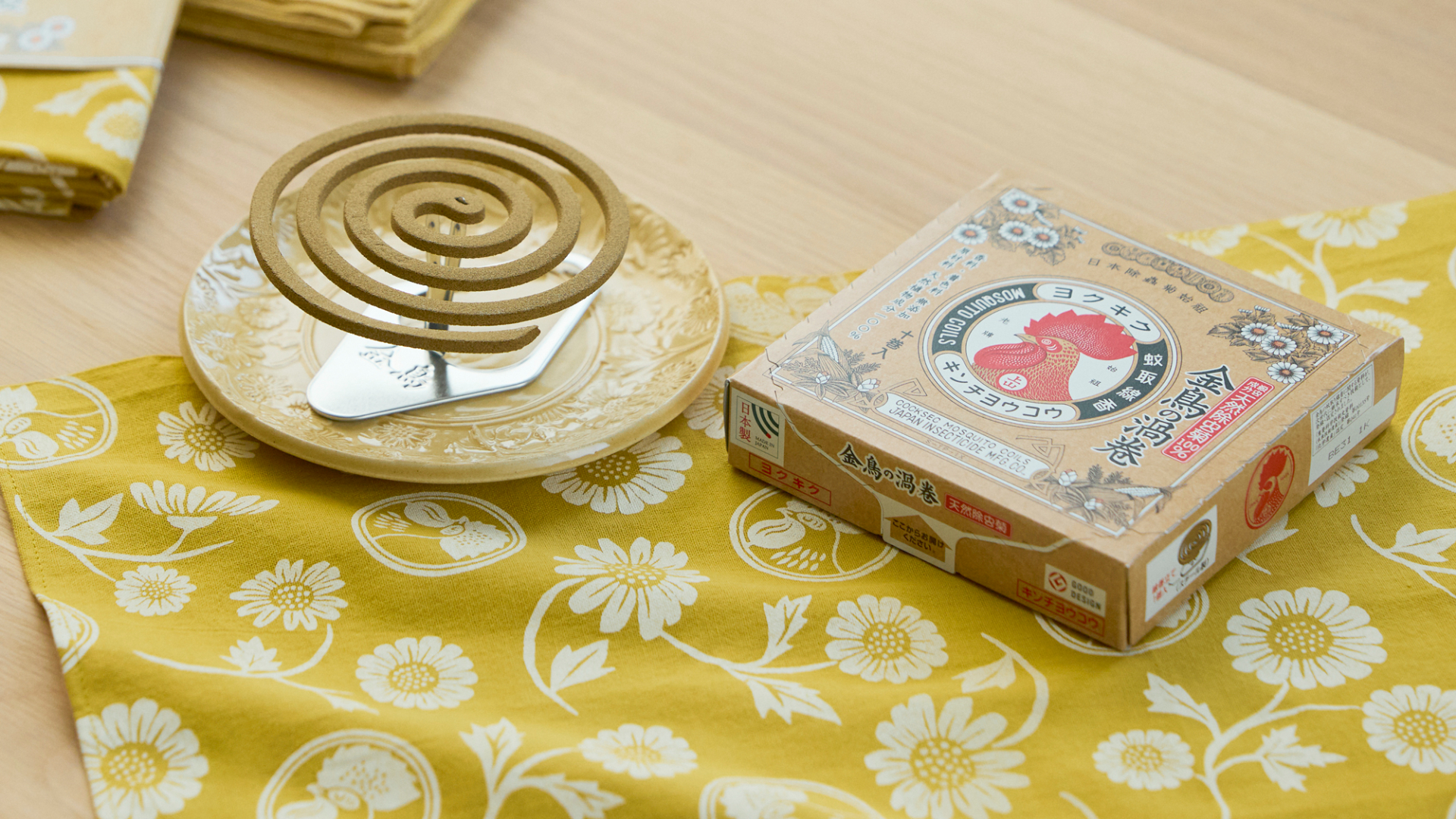 新作「金鳥の渦巻と瀬戸焼の線香皿セット」（4070円）。中川政七商店がパッケージをデザインした「天然除虫菊 金鳥の渦巻」と、金鳥ならではの絵柄が浮かぶ瀬戸焼の線香皿を菊染め手ぬぐいで包んだセット