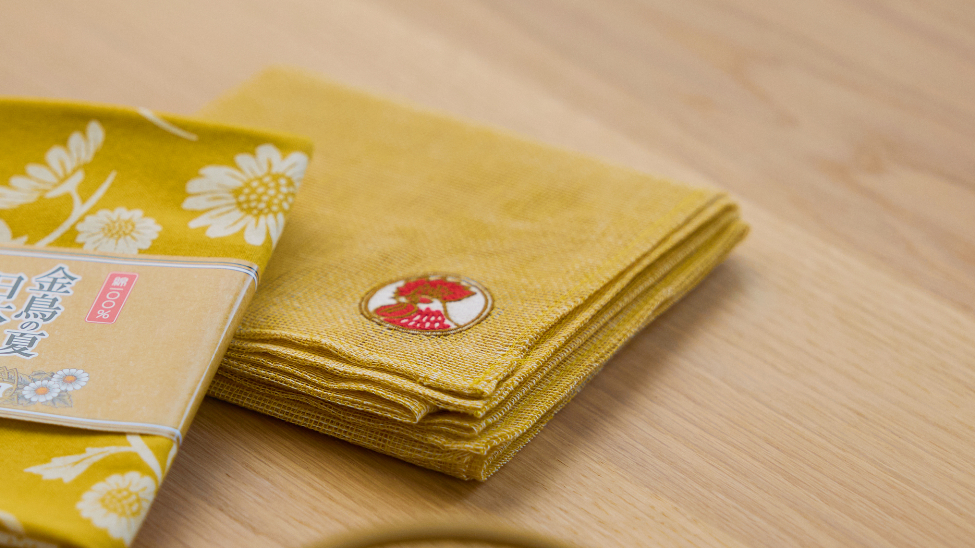 新作「菊染め花ふきん 天然金鳥」（1320円）。風は通すが蚊は通さない目の粗さが特徴のかや織を活かした乾きやすいふきん。染めには、金鳥の渦巻の成分のひとつである除虫菊にちなんだ菊の花を用いた