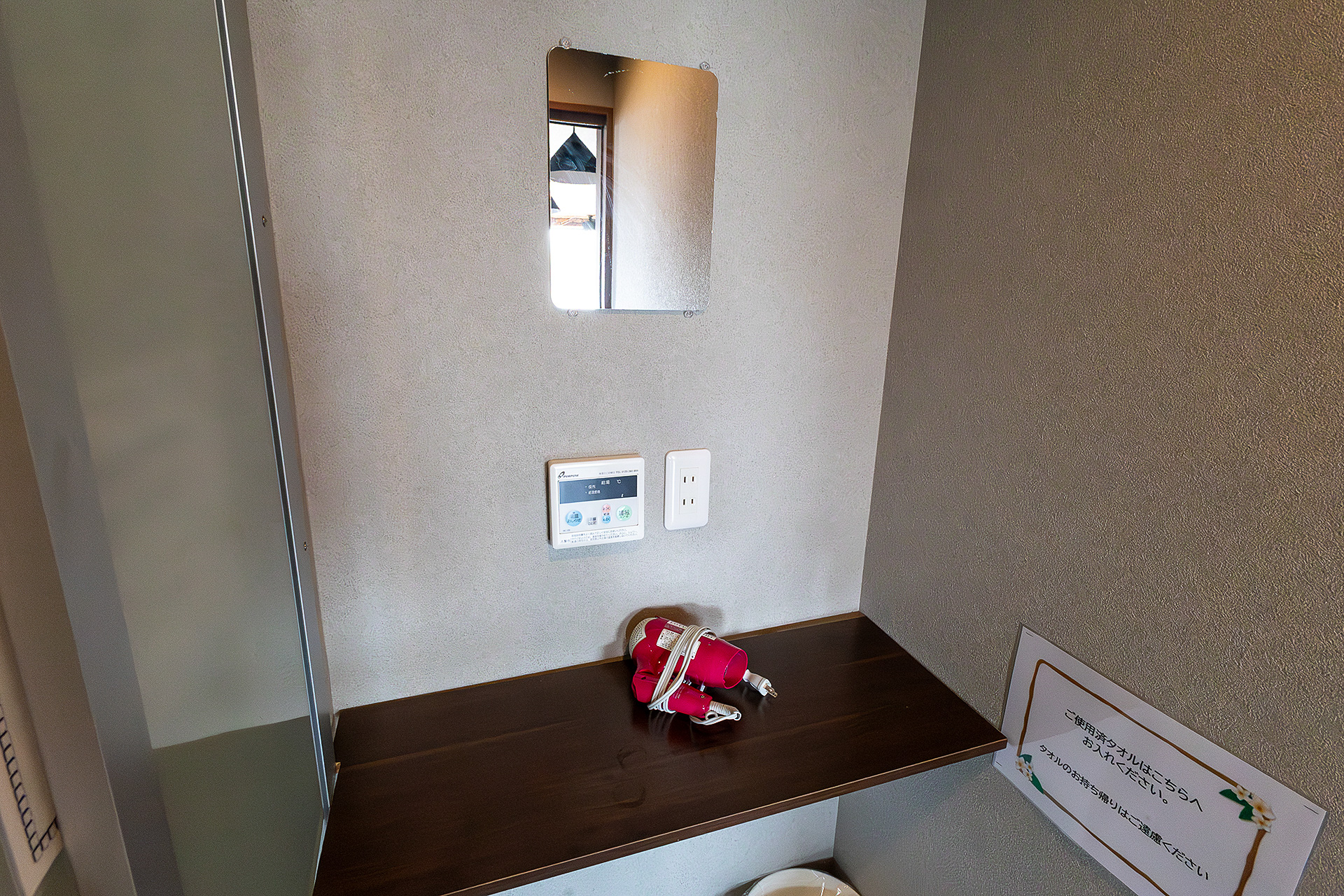脱衣所の広さも十分あり、着替えを置く棚も用意されている。鏡とドライヤーもある