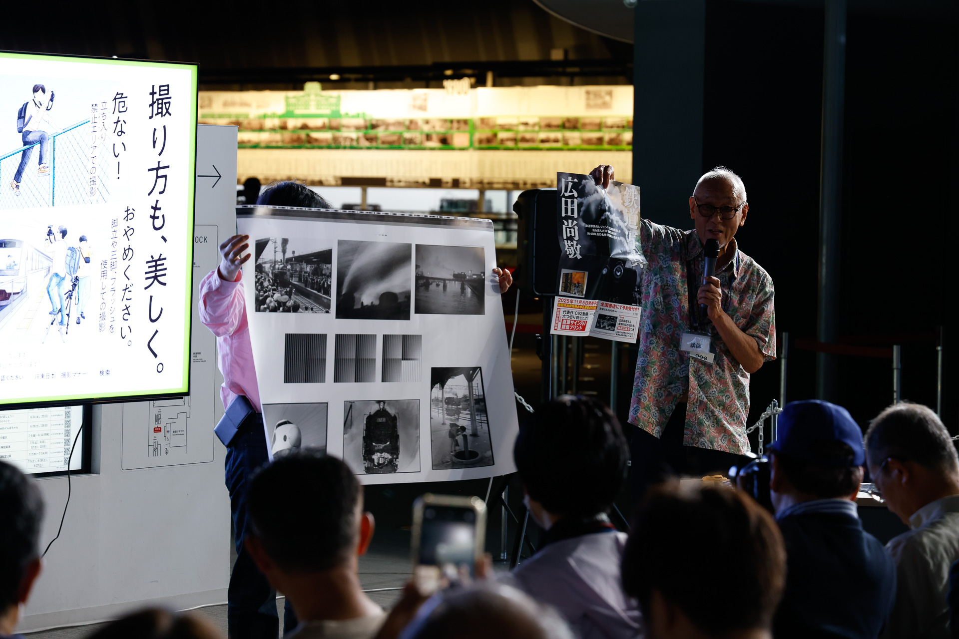 「鉄道写真 広田尚敬」のサンプルとポスターを示す広田氏。すでに予約受付が行なわれており、初回分には出荷特典が付くそうである