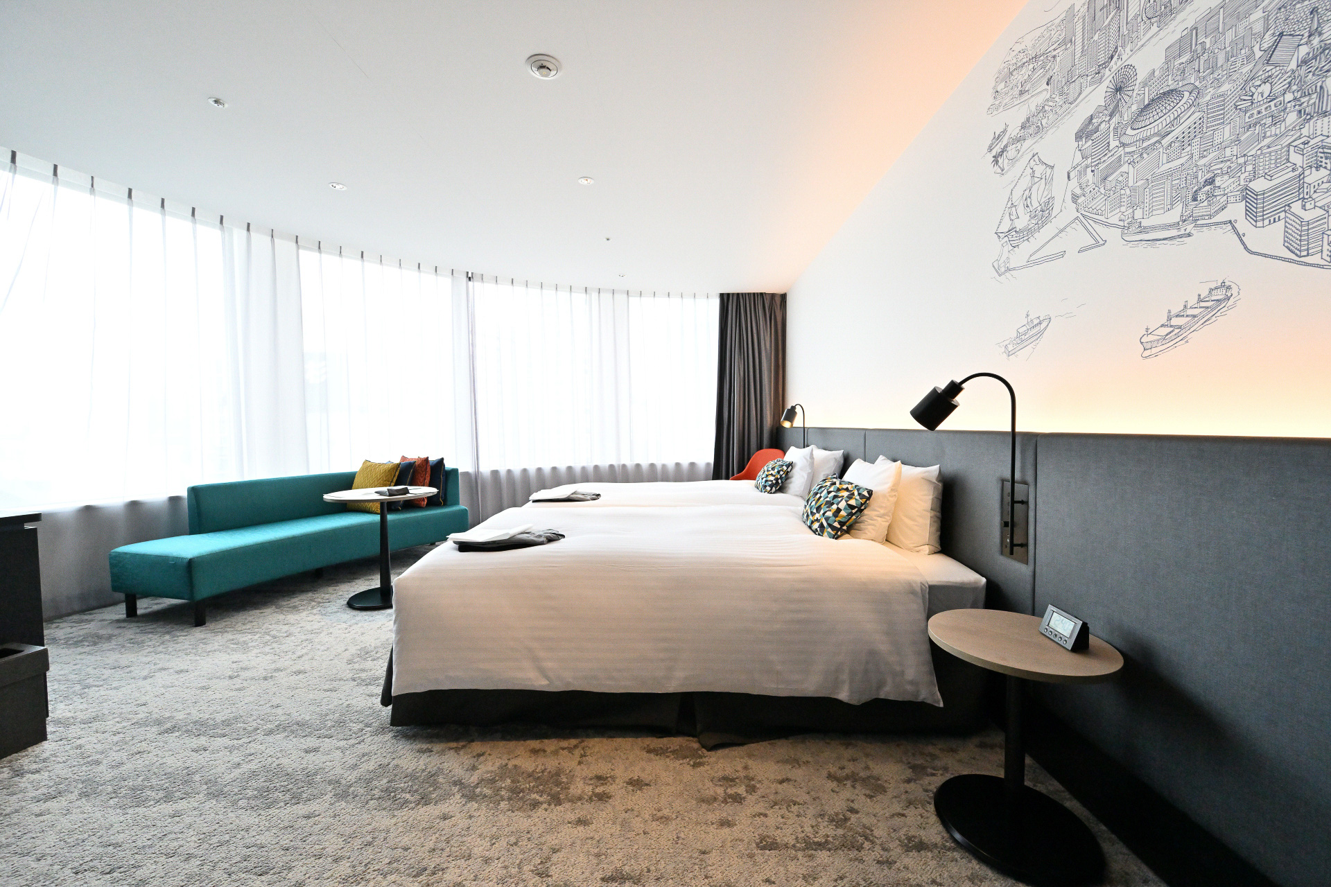 建物の形状にあわせたアール面の窓で、梅田地区の景観が一望できる。エクストラベットをいれることで最大4名まで宿泊可能。家族連れや友達同士など幅広いニーズに対応可能