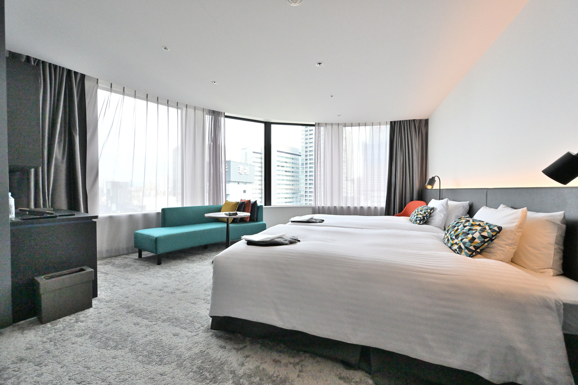 建物の形状にあわせたアール面の窓で、梅田地区の景観が一望できる。エクストラベットをいれることで最大4名まで宿泊可能。家族連れや友達同士など幅広いニーズに対応可能