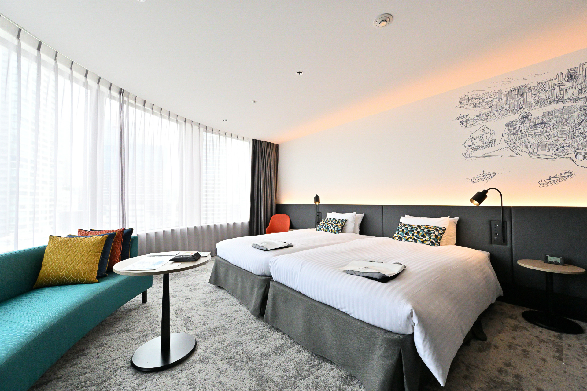 建物の形状にあわせたアール面の窓で、梅田地区の景観が一望できる。エクストラベットをいれることで最大4名まで宿泊可能。家族連れや友達同士など幅広いニーズに対応可能