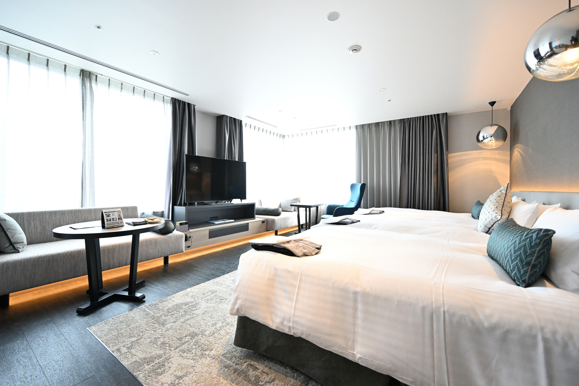 大阪の景色を見渡す大きな二面窓のジュニアスイート。大きなソファや椅子でくつろぎながらゆったりとした時間を過ごすことができる