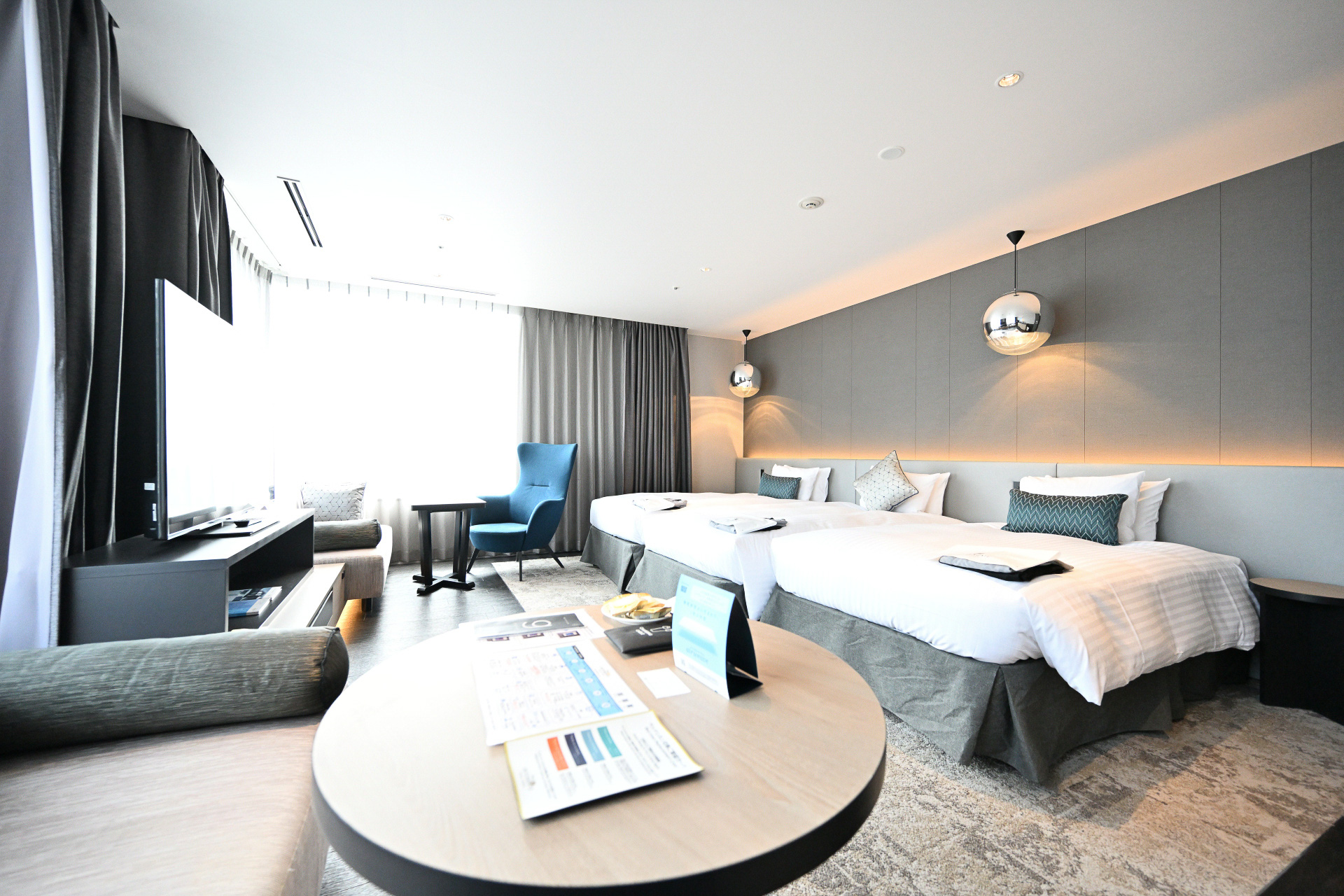 大阪の景色を見渡す大きな二面窓のジュニアスイート。大きなソファや椅子でくつろぎながらゆったりとした時間を過ごすことができる