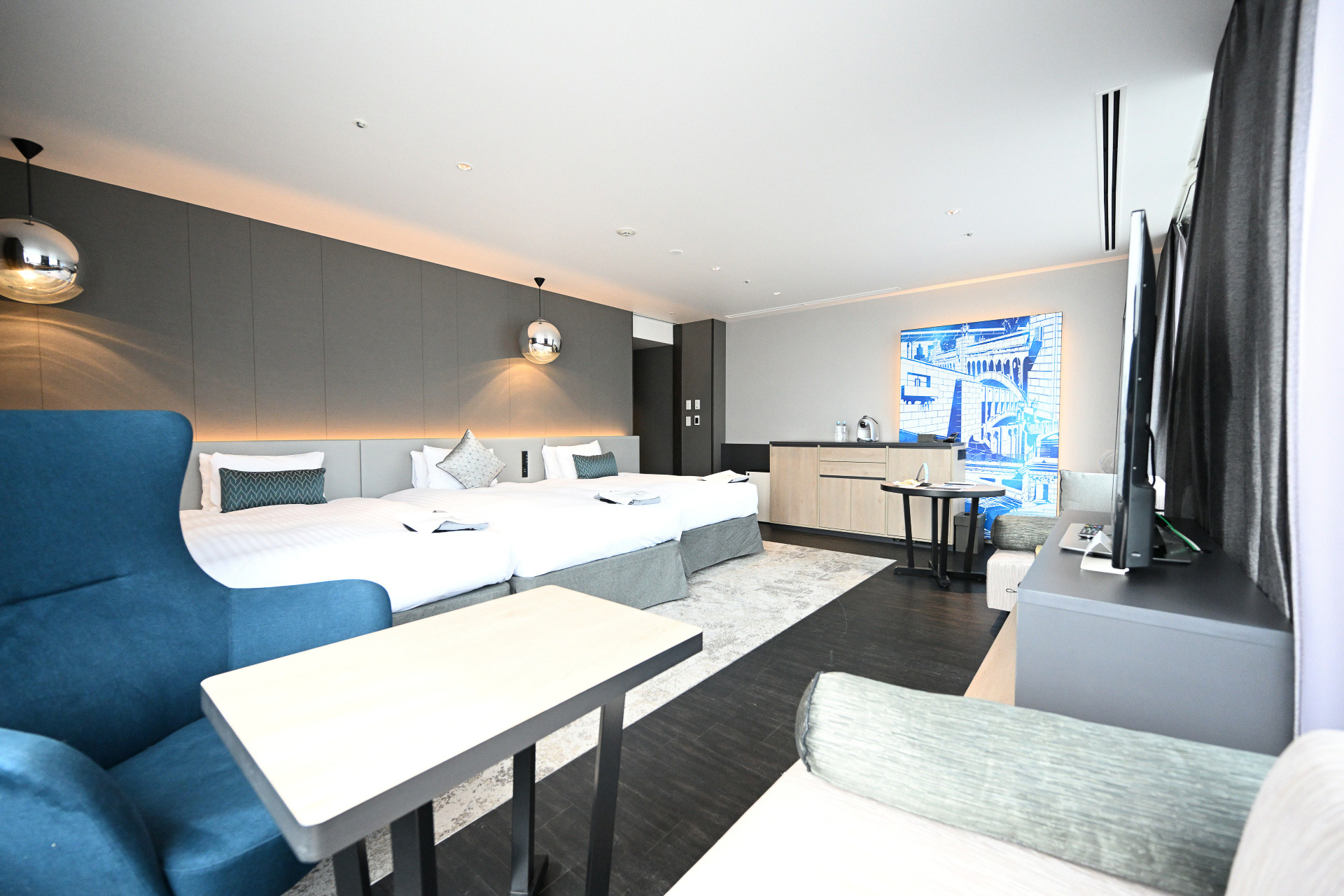 大阪の景色を見渡す大きな二面窓のジュニアスイート。大きなソファや椅子でくつろぎながらゆったりとした時間を過ごすことができる