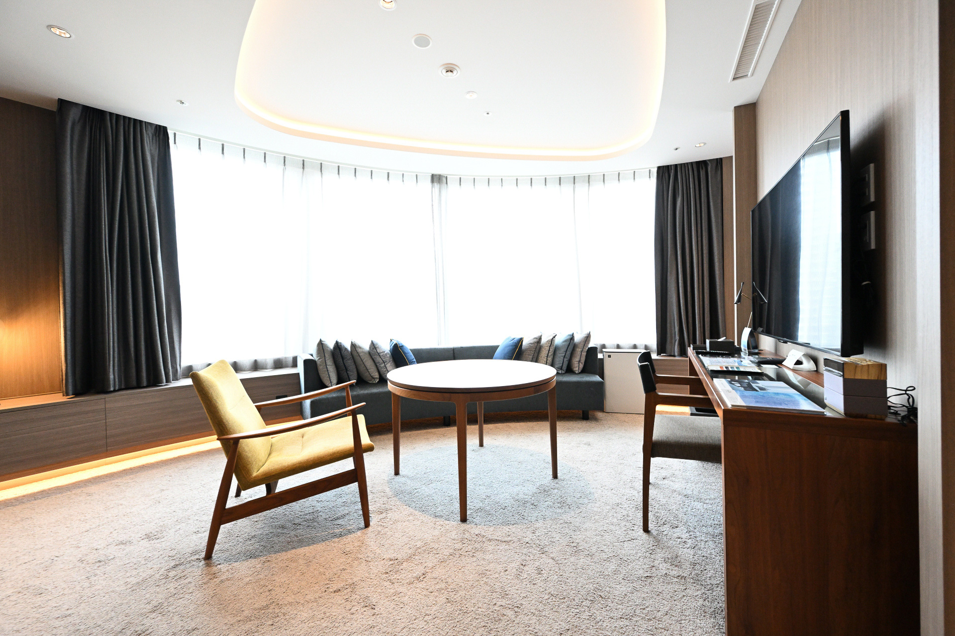 ホテルインターゲート大阪 梅田のフラグシップルーム、「インターゲートスイート」。アール形状の大きな窓を備え、大阪の景色を望むリビングルーム。そして仕切られたベッドルームは我が家のようにくつろぐことができる