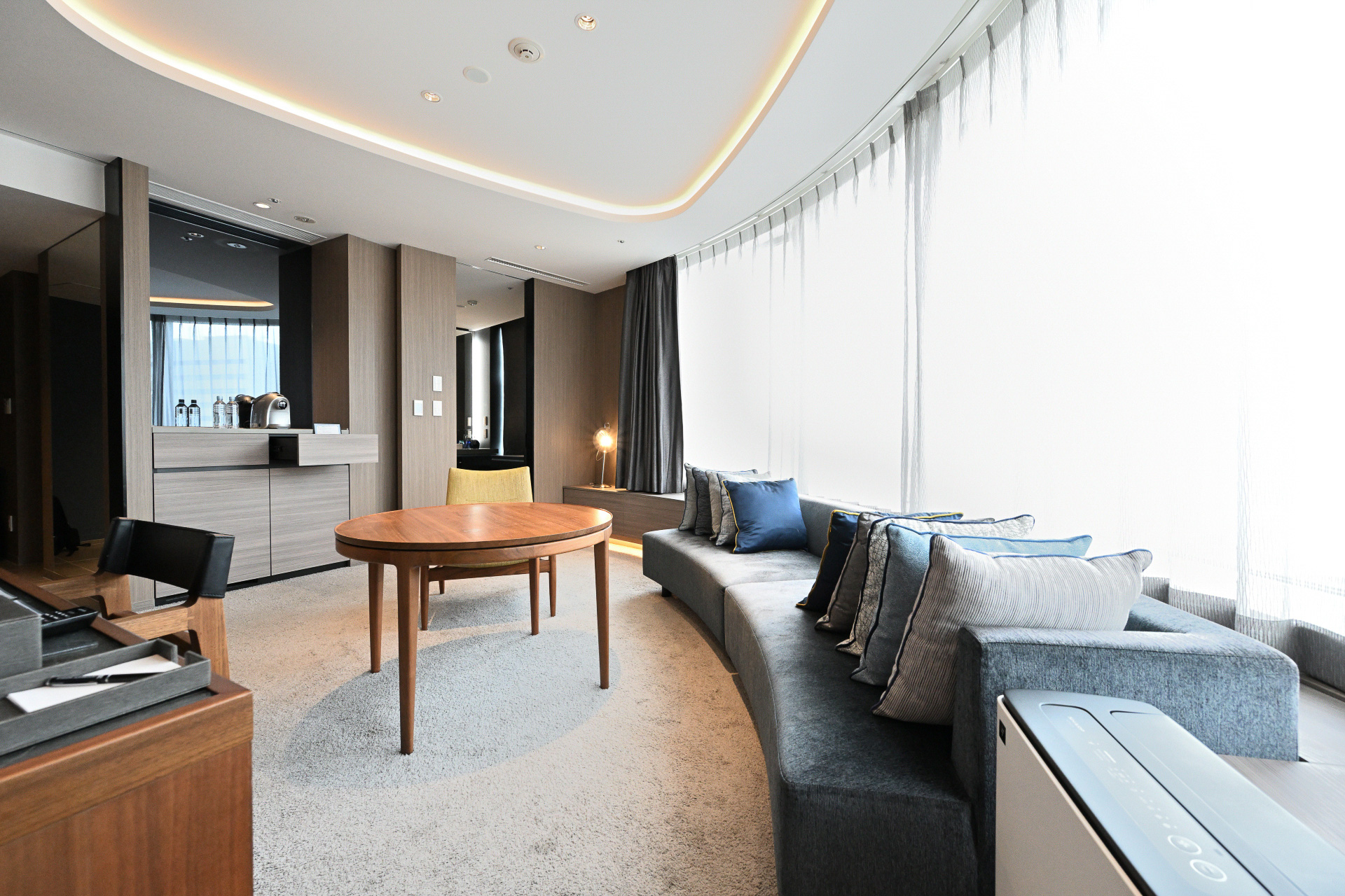 ホテルインターゲート大阪 梅田のフラグシップルーム、「インターゲートスイート」。アール形状の大きな窓を備え、大阪の景色を望むリビングルーム。そして仕切られたベッドルームは我が家のようにくつろぐことができる