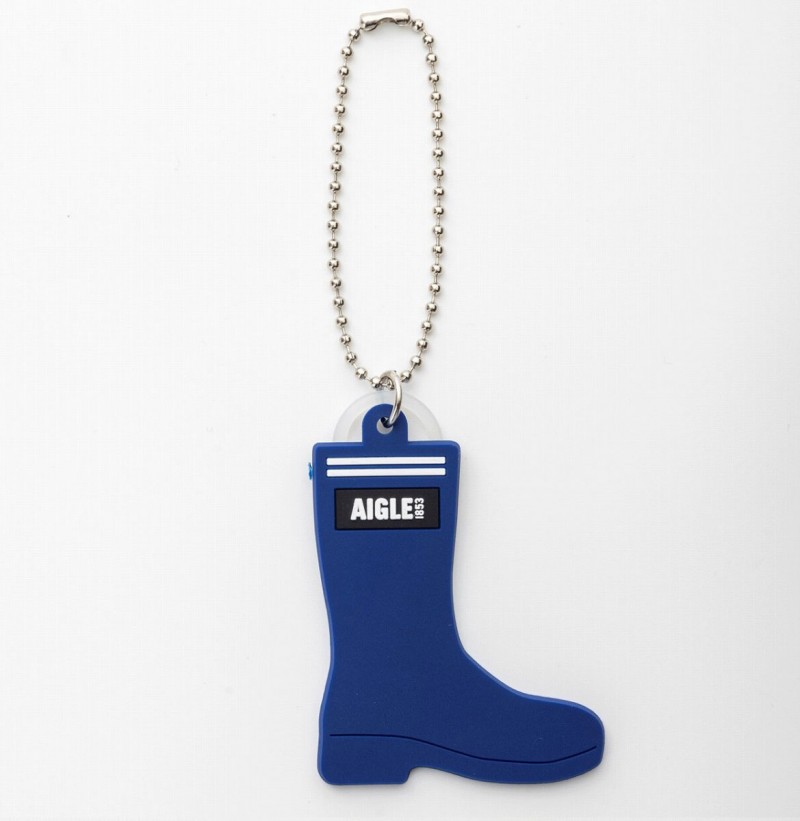 ラバーブーツを思わせる帆布調とラバー調の異素材を組み合わせたトートバッグ「AIGLE TOWN⇔OUTDOOR TOTE BAG BOOK」。サイズは約34～48×15×32cm（幅×奥行き×高さ）、取り外し可能なショルダーストラップの長さ115cm、チャームは青