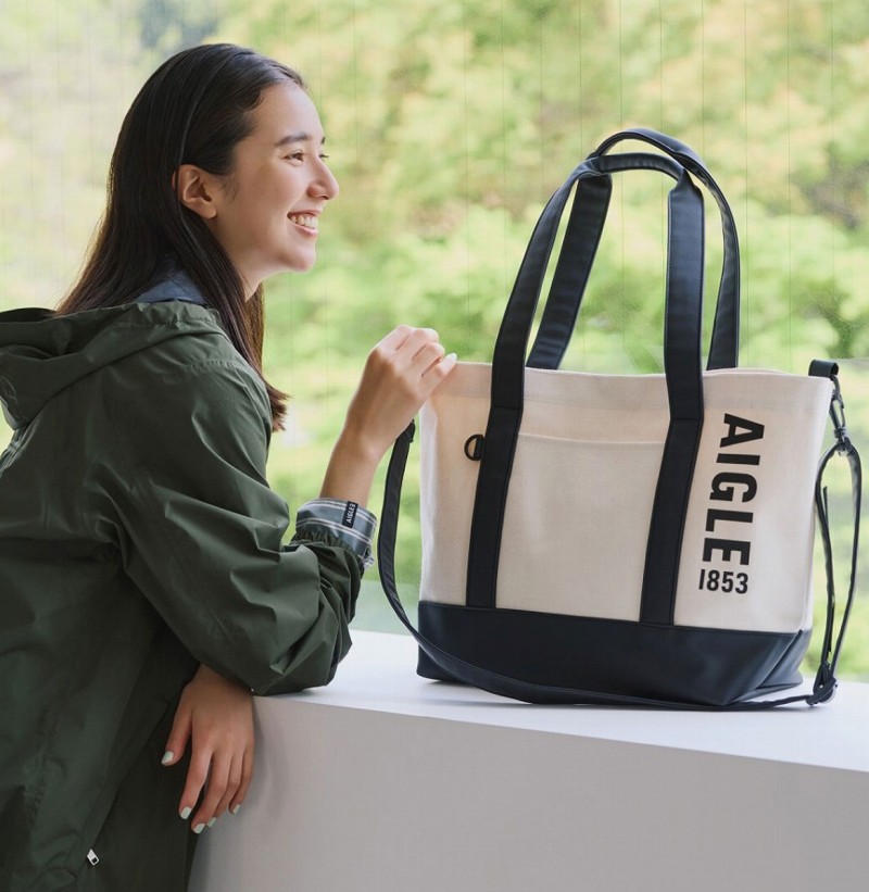 ラバーブーツを思わせる帆布調とラバー調の異素材を組み合わせたトートバッグ「AIGLE TOWN⇔OUTDOOR TOTE BAG BOOK」。サイズは約34～48×15×32cm（幅×奥行き×高さ）、取り外し可能なショルダーストラップの長さ115cm、チャームは青