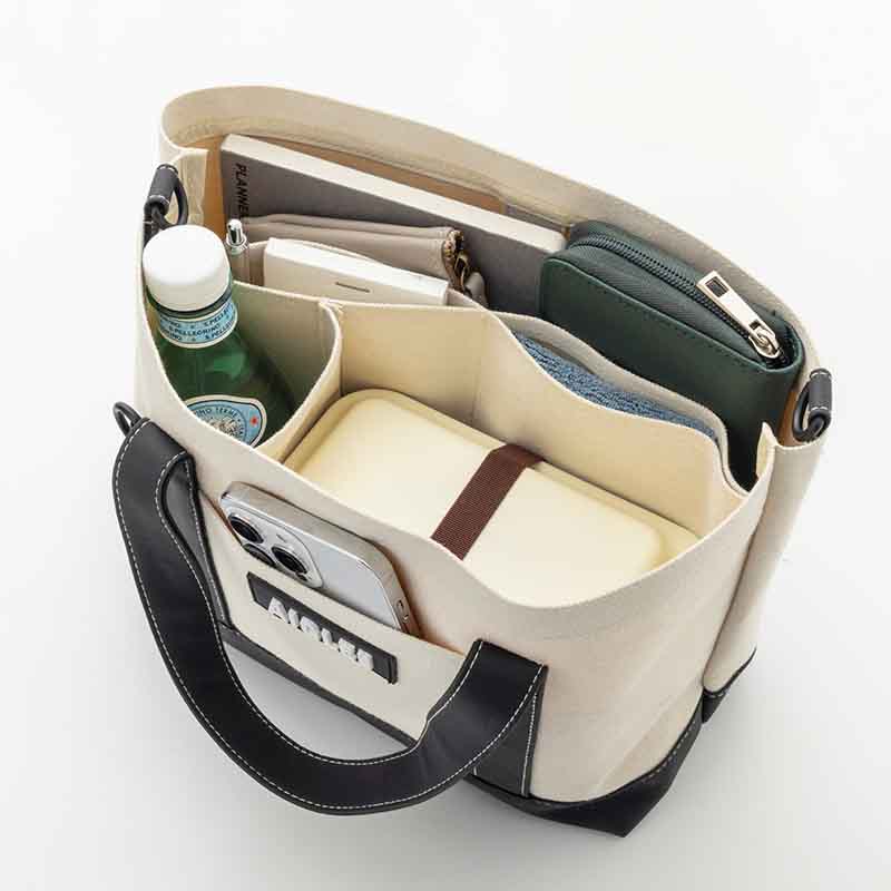 ファミリーマート限定のミニトートバッグ「AIGLE TOWN⇔OUTDOOR MINI TOTE BAG BOOK」は、6つのポケット付きで整理整頓しやすいデザイン。サイズは約33×11.5×22cm（幅×奥行き×高さ）、取り外し可能なショルダーストラップの長さ128cm、チャームは赤