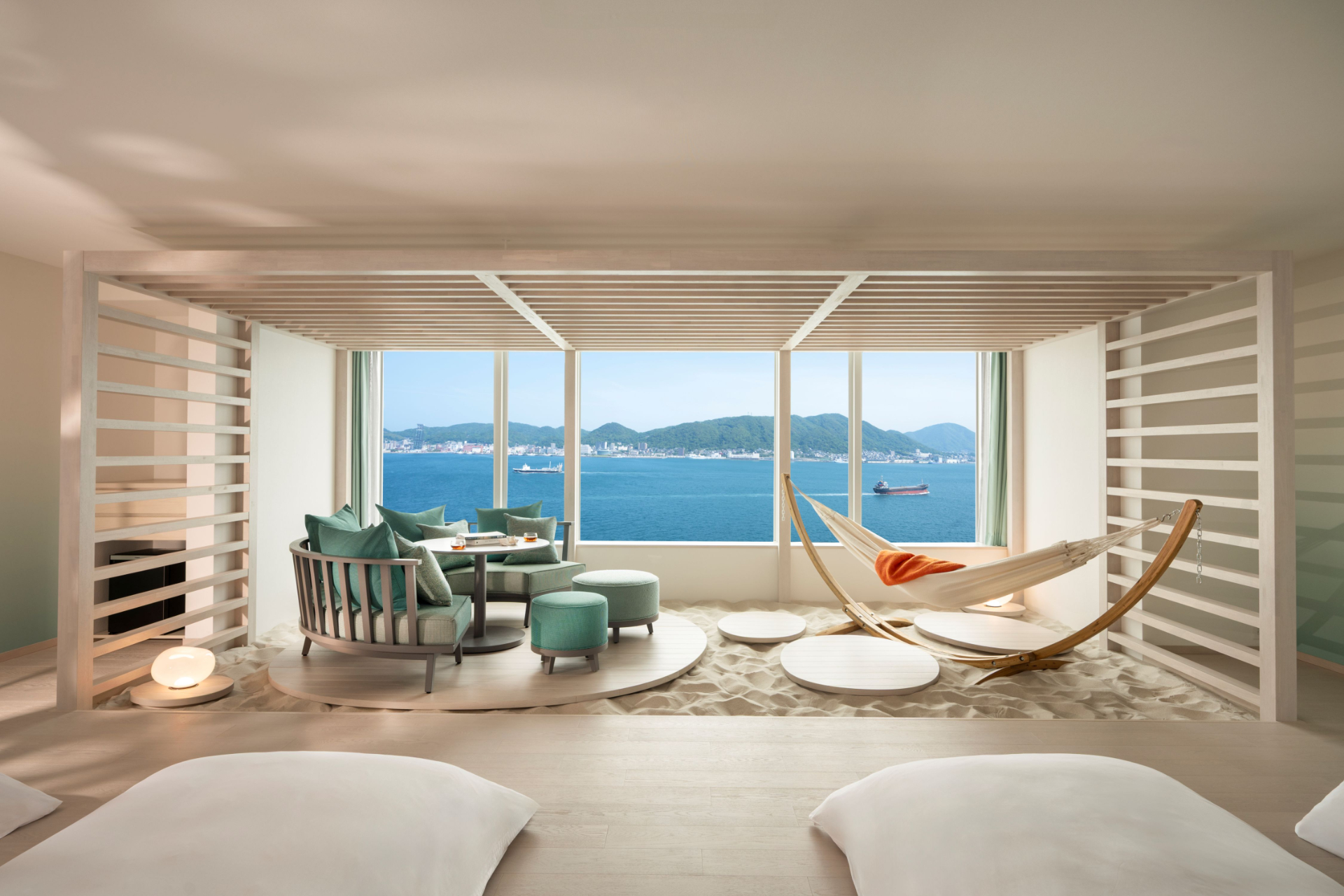 リゾートの浜辺をイメージし、砂浜を敷き詰めたリビングにハンモックやソファを設置する「海峡カバナスイート」
