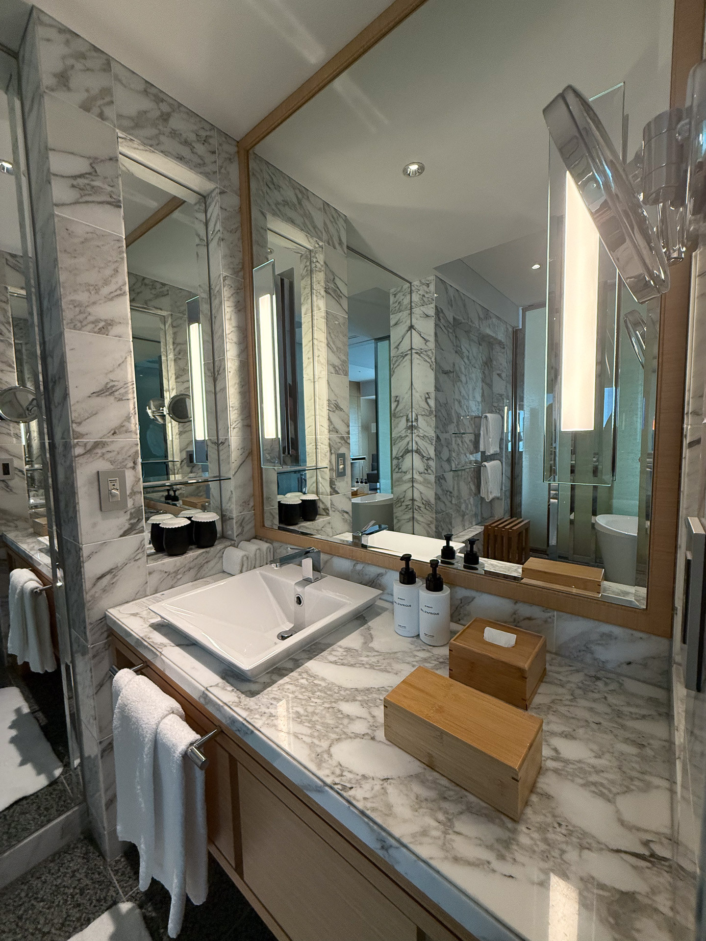 明るくて使いやすい洗面台。手前の木箱に髭剃りや歯ブラシなどのアメニティを収納する