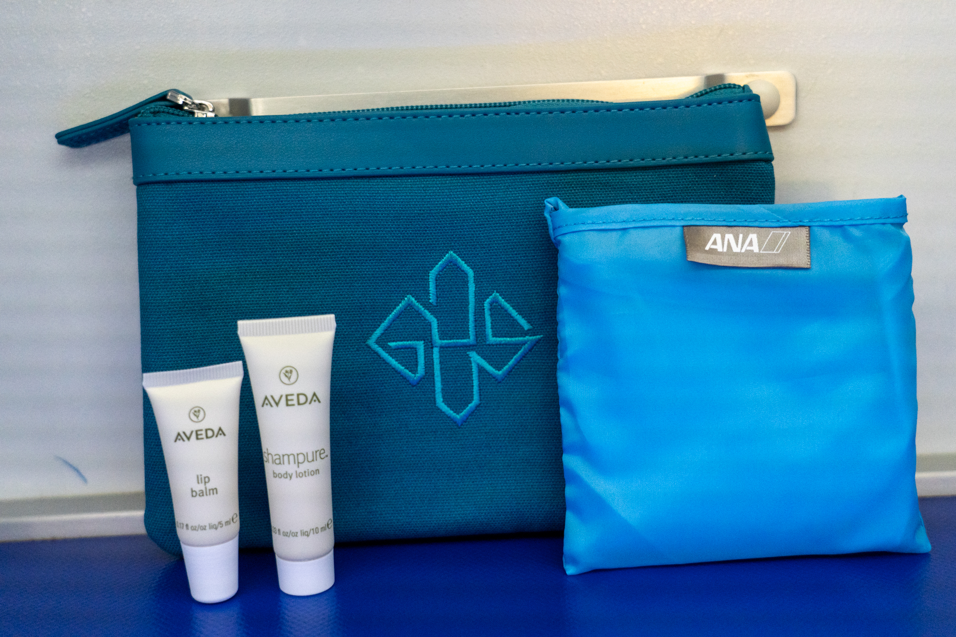 ANAオリジナルポーチ（エッティンガー）にアヴェダのリップとボディローション、ANAオリジナルエコバッグが入ったビジネスクラスのアメニティキット