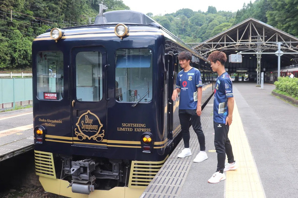 「青の交響曲」に乗車する田村亮介選手・鈴木大誠選手（写真提供：奈良クラブ）