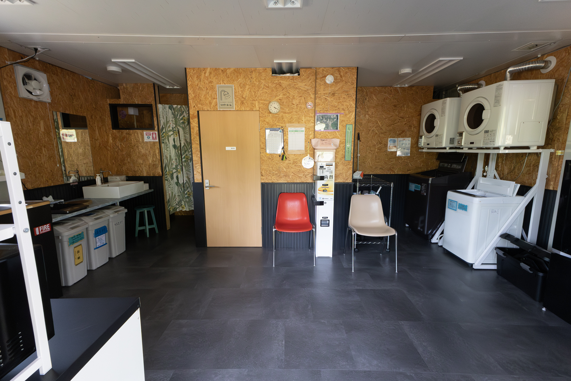 入り口から見た光景。真ん中がシャワールームで左側にシンクがある。その奥に女性用のトイレがあり、トイレ入口の部分には化粧ができるスペースがある。右側には冷蔵庫や洗濯機、乾燥機がある