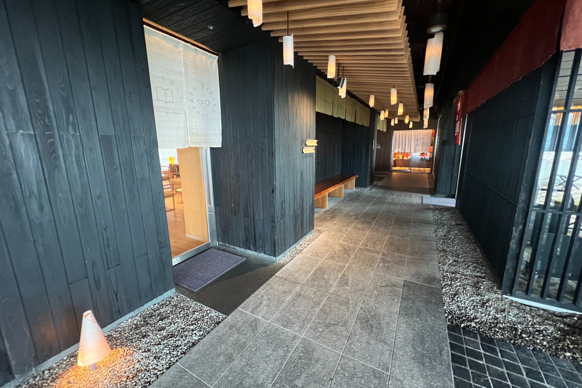 黒壁に囲まれた石畳の廊下など、館内は“温泉街”をイメージした造り