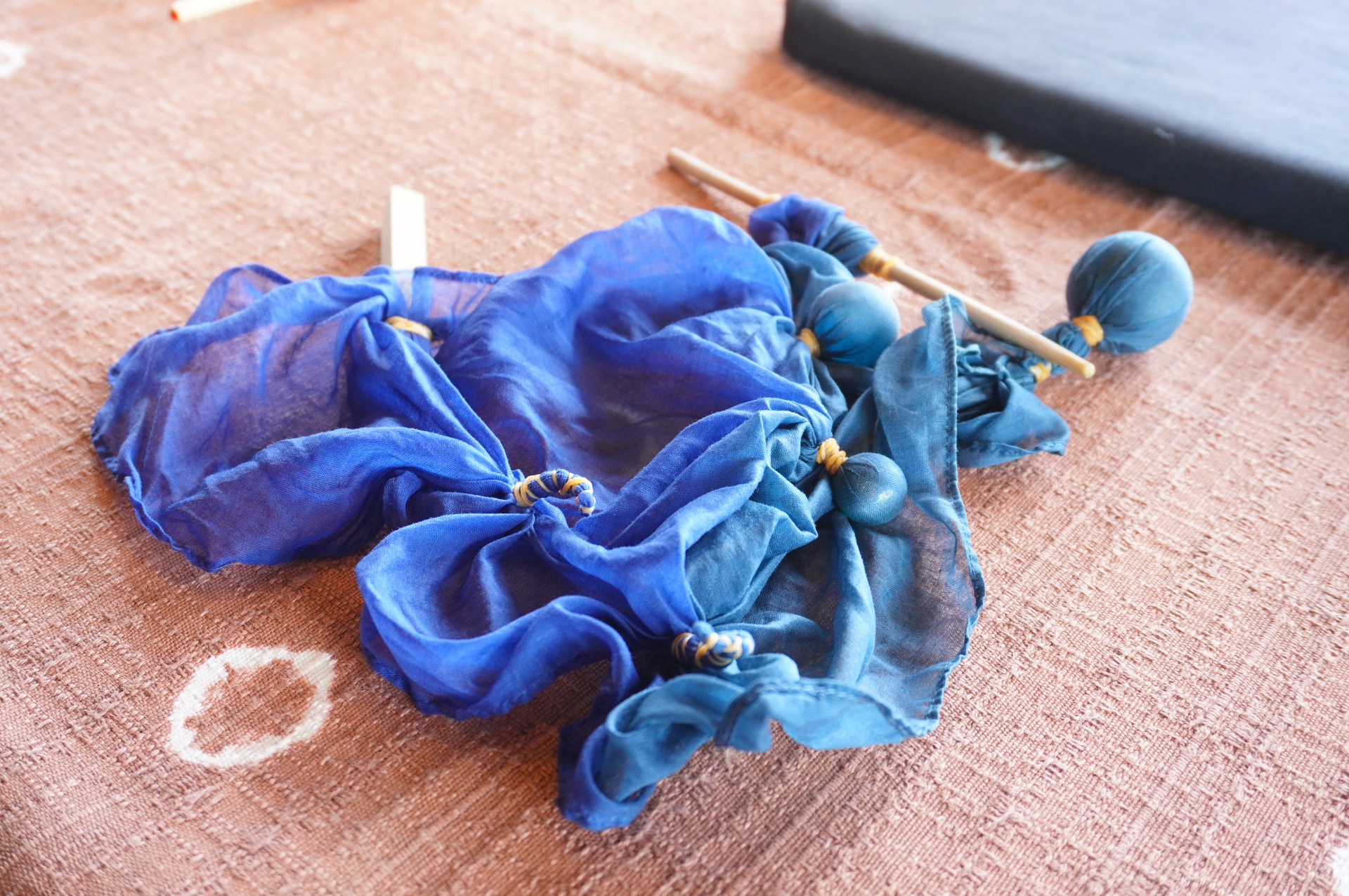 あらかじめ染色された綿ハンカチに、ビー玉や棒、輪ゴムなどを使って“模様”になる部分を作ります