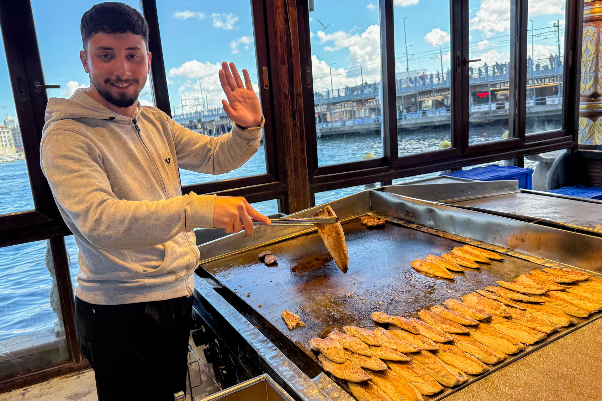 停泊している船の上でサバを焼くお兄さん