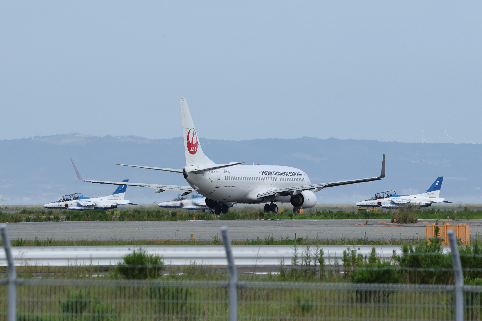 ブルーインパルス第2・第3編隊の着陸を待つJALの737-800と、その奥をタキシングしていく第1編隊