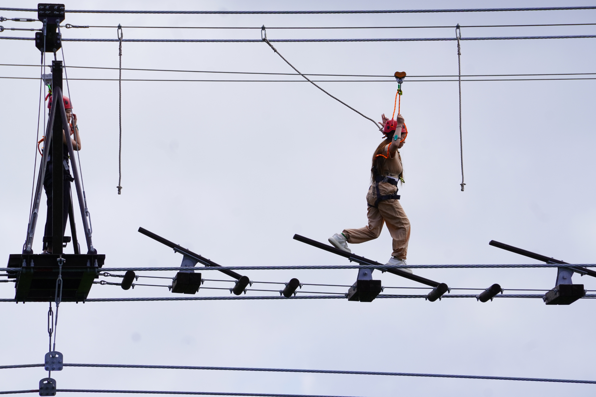 「スカイエンドトレッキング」はロープを頼りに空の上を歩く全長84mの難関アスレチック。不安定な踏み板の真下はジャングルの谷底でスリル満点。体験前には、ナビゲーターがしっかりと命綱を装着してくれる