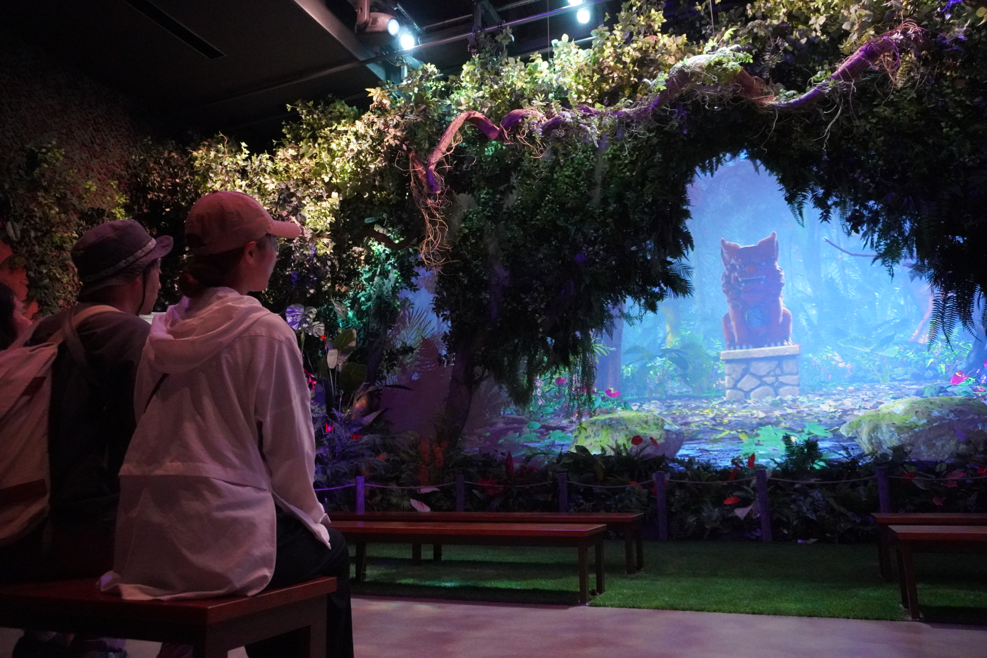 屋内シアター型アトラクション「やんばるフレンズ」。プレショーでは研究所のような空間でやんばるの森の生態について学びつつ、動くはずのない絵が生き物のようにはしゃぎだし……。メインシアターへ移動すると、ヤンバルクイナの「ジャン」と守り神のシーサー「シン」が登場し、ゲストとの会話や問答を繰り広げる。突然雨が振り出して濡れちゃうかも？