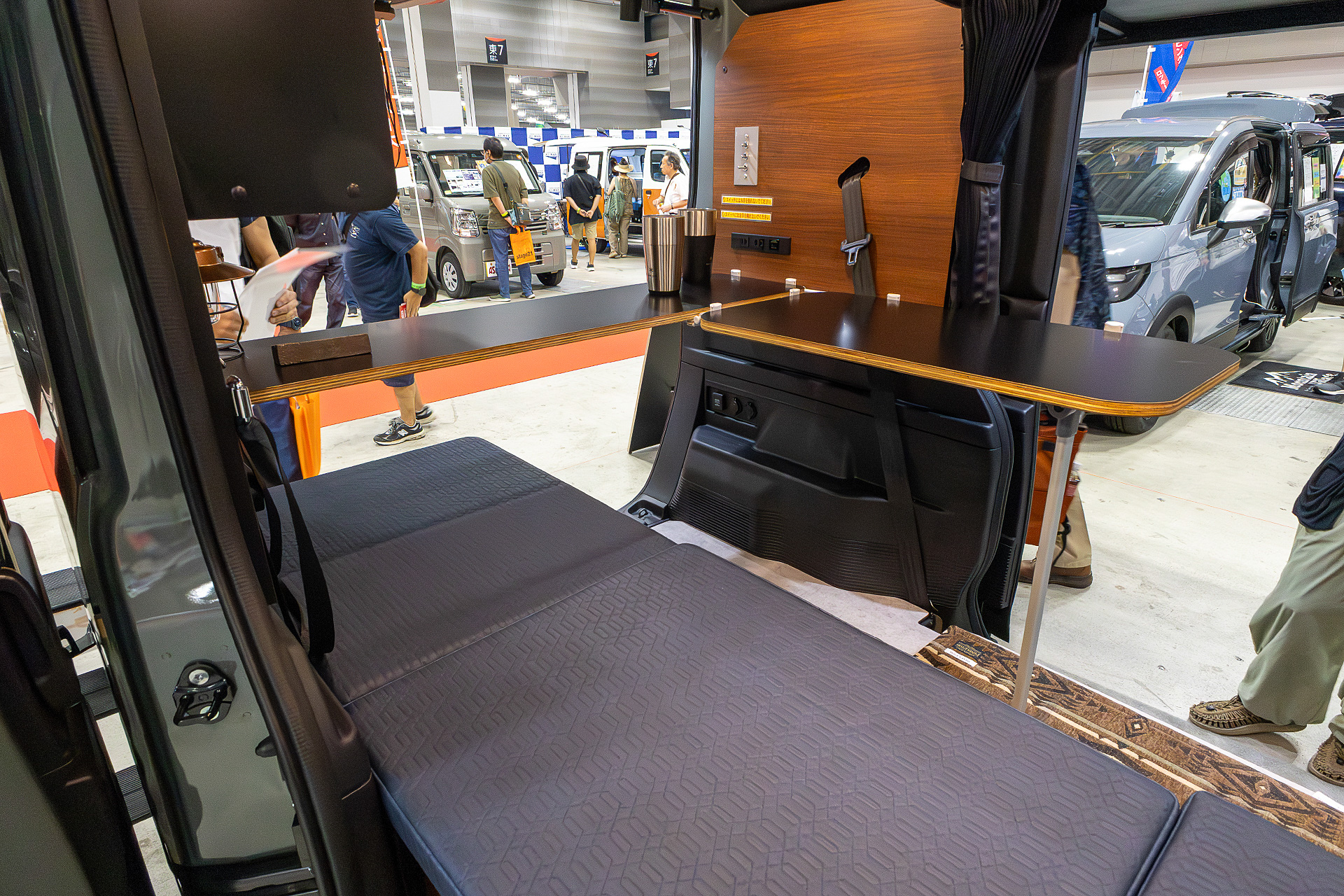 L字テーブルにするとベッドから起きて座り直すだけでテーブルで飲み物を飲んだり食事できたりする。仕事でクルマ移動をするときはオフィス的にも使える