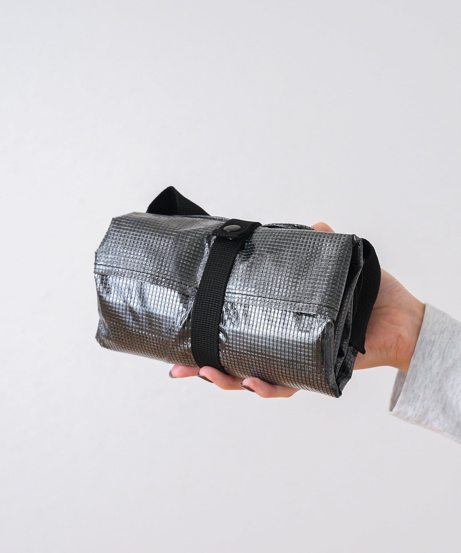 使わないときは付属のベルトでコンパクトに折りたため、バッグ使用中はベルトが衣類を提げるジャケットホルダー代わりに