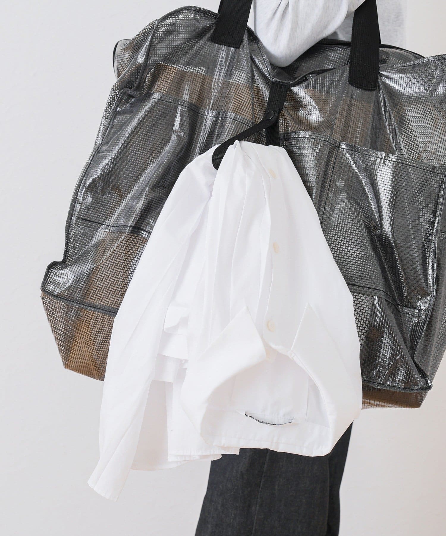 使わないときは付属のベルトでコンパクトに折りたため、バッグ使用中はベルトが衣類を提げるジャケットホルダー代わりに