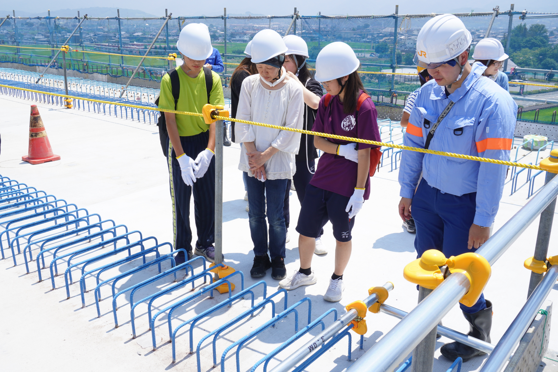 工事中の常永川橋りょうの桁の上に特別にのぼれる「地域インフラ見学会」開催。JR東海の職員が分かりやすいパネルで子供たちに解説した