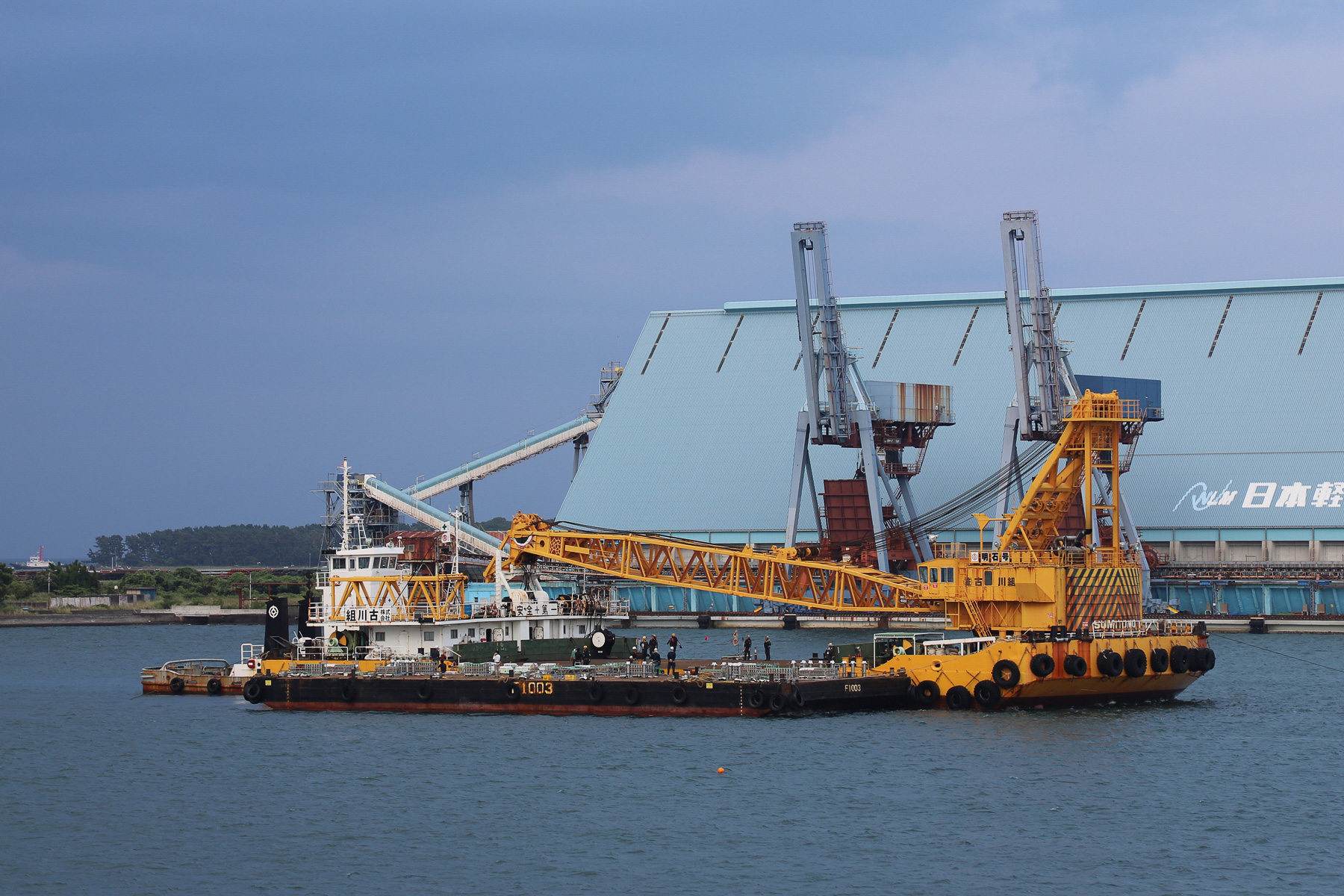 花火を積んだ台船がクレーン船に横抱きされて入ってきた