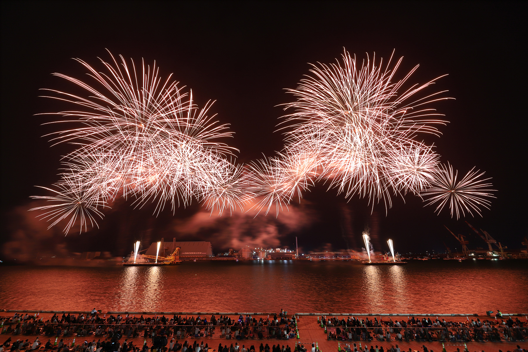 みなと祭りの花火は観客席に近い。超広角14mmでの撮影で、前列にいると真上に近い角度で花火が覆いかぶさってくるように見える
