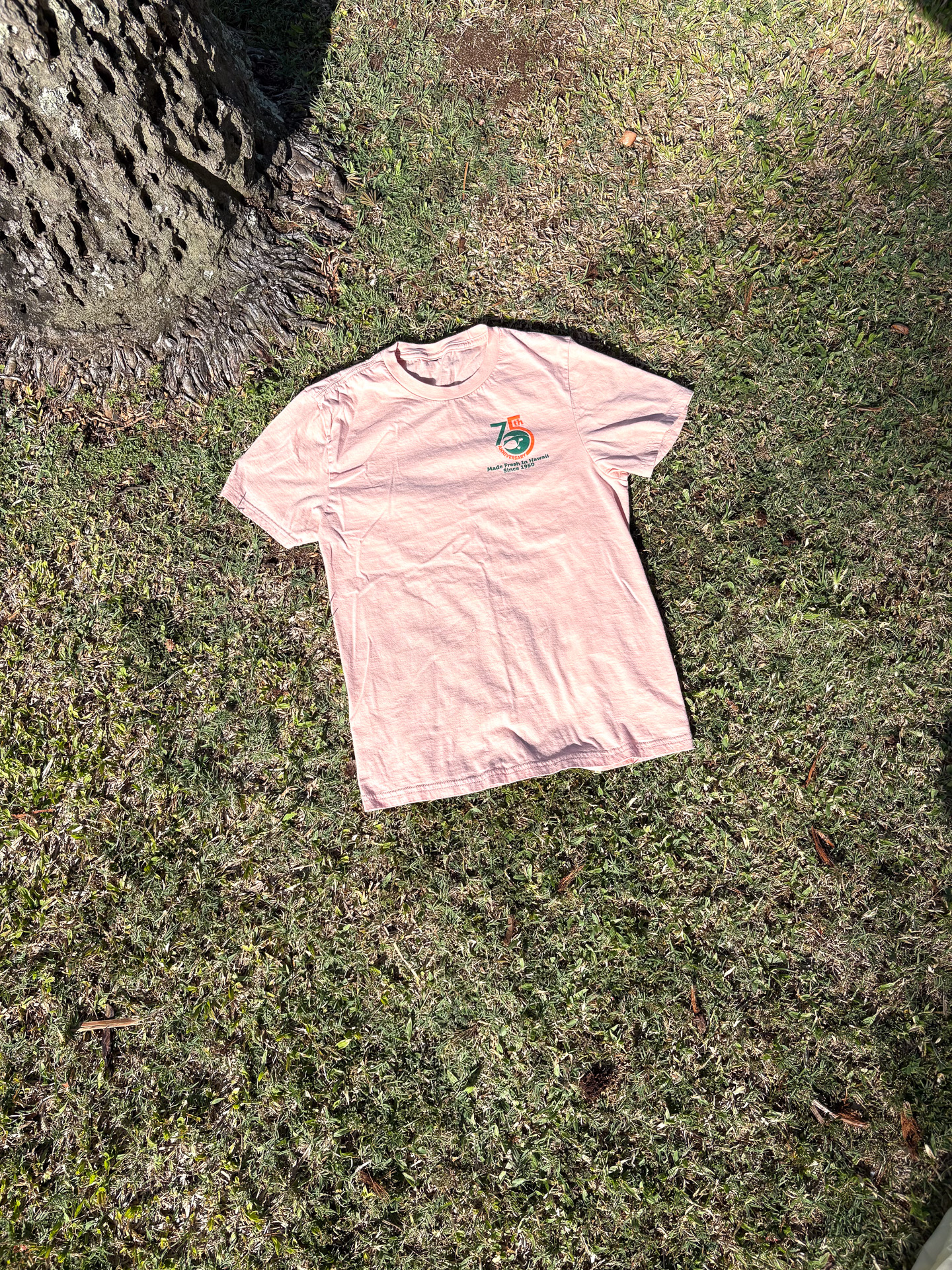 サーモンピンクの75周年オリジナルTシャツ（18ドル）