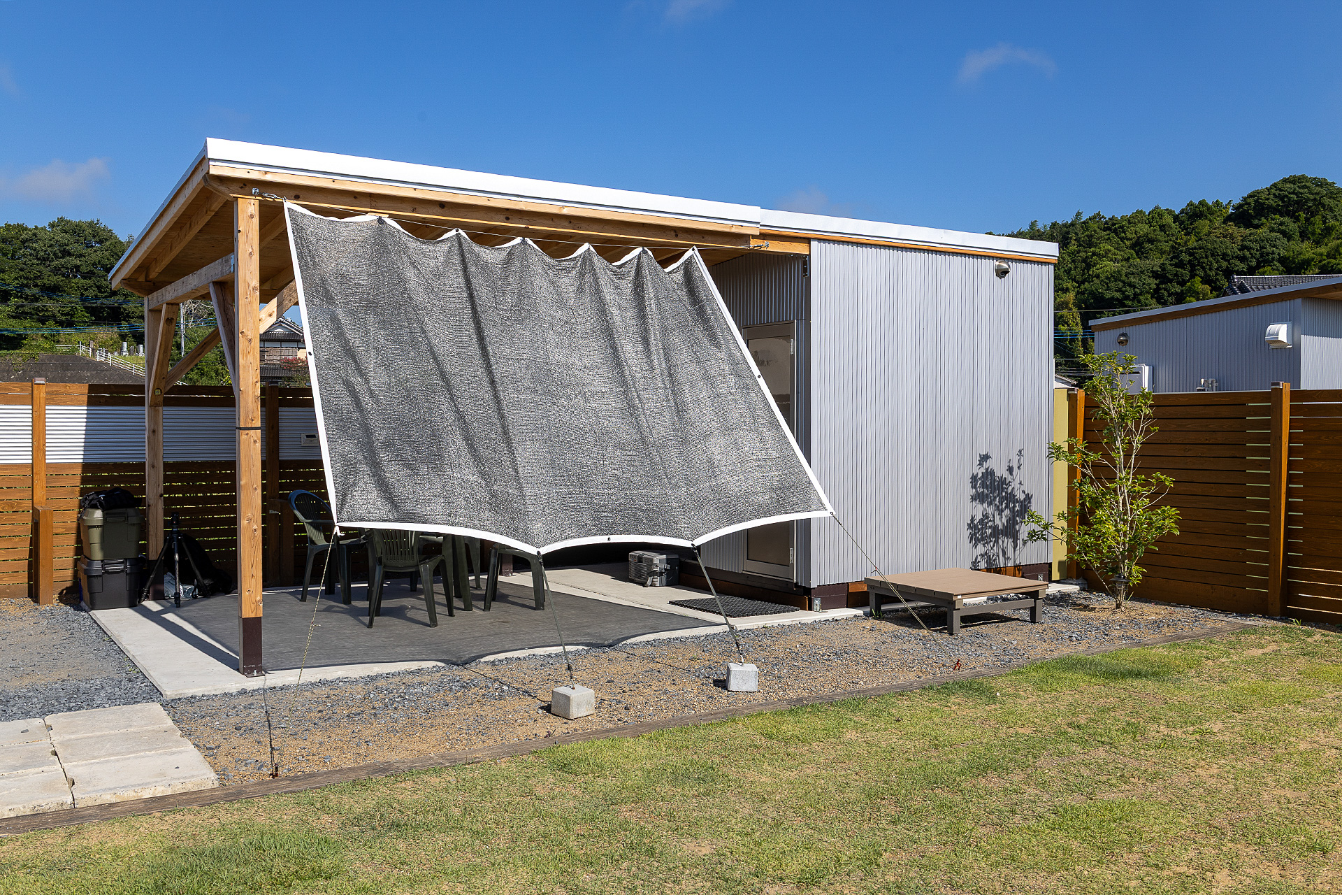 芝生スペースの横にあるのがシャワールームとトイレのある建屋。日よけがある部分はコンクリート敷きの食事などをできるスペース
