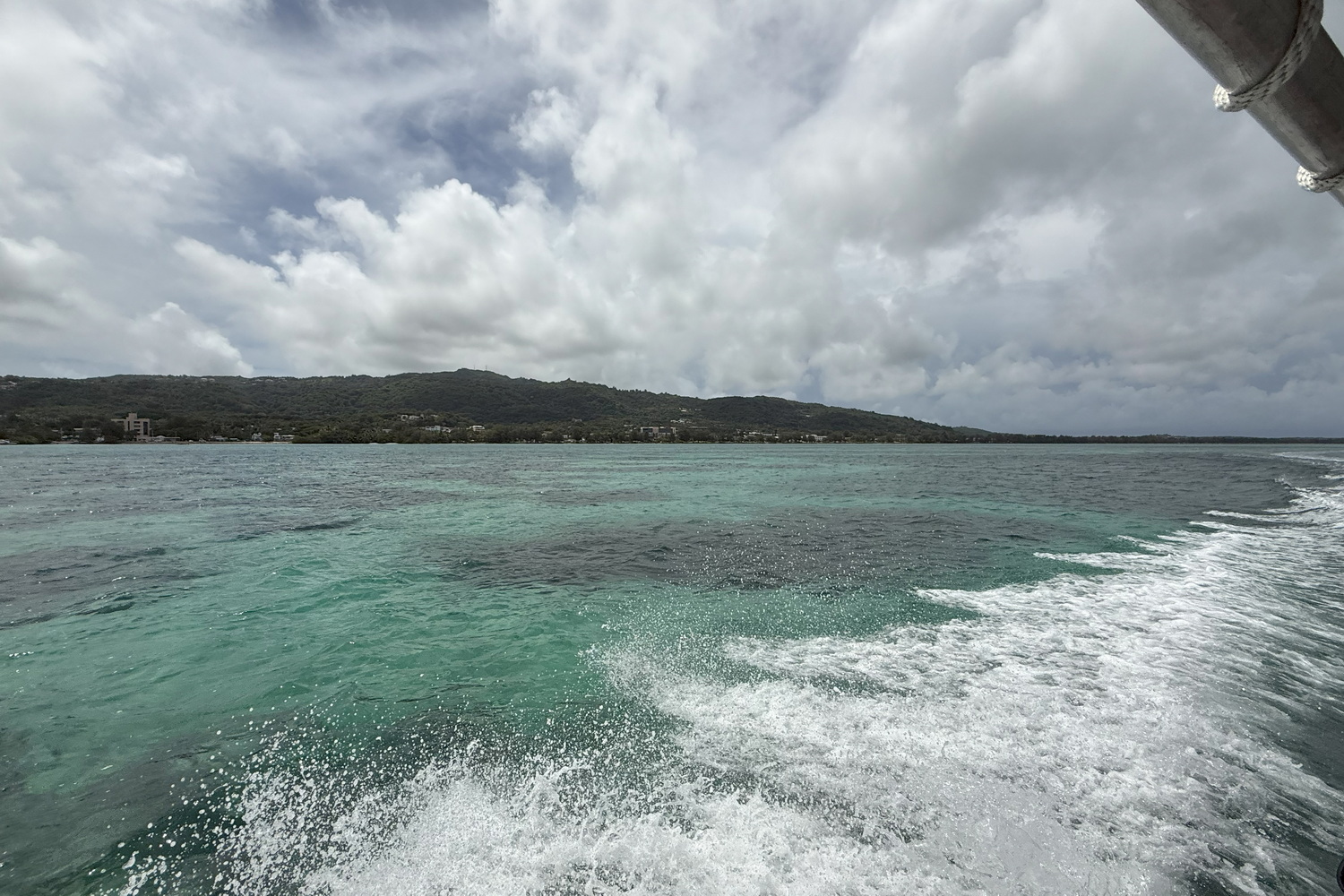 ダイビングボートに乗船して沖合いから見たサイパン島。今回は運わるく曇りがちではあったが、それでもやはり海の透明度は抜群。水中に黒っぽく見えているのは水底にあるサンゴの根