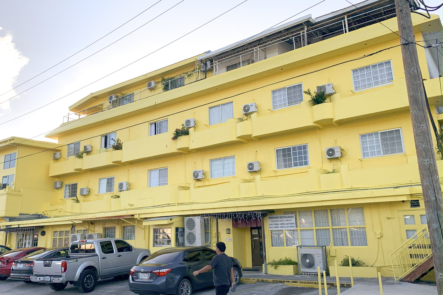 HIMAWARIホテル（写真左は2019年時点のもの。現在はエントランス周辺の様子が若干変わっている）。写真右はホテルとスーパーマーケットの入口で、レストランの入り口は手前にある