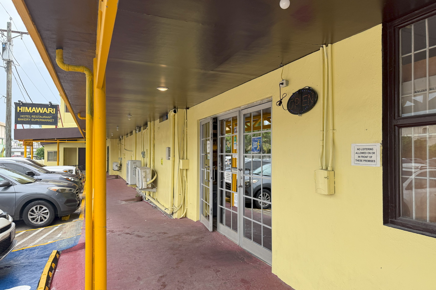 HIMAWARIホテル（写真左は2019年時点のもの。現在はエントランス周辺の様子が若干変わっている）。写真右はホテルとスーパーマーケットの入口で、レストランの入り口は手前にある