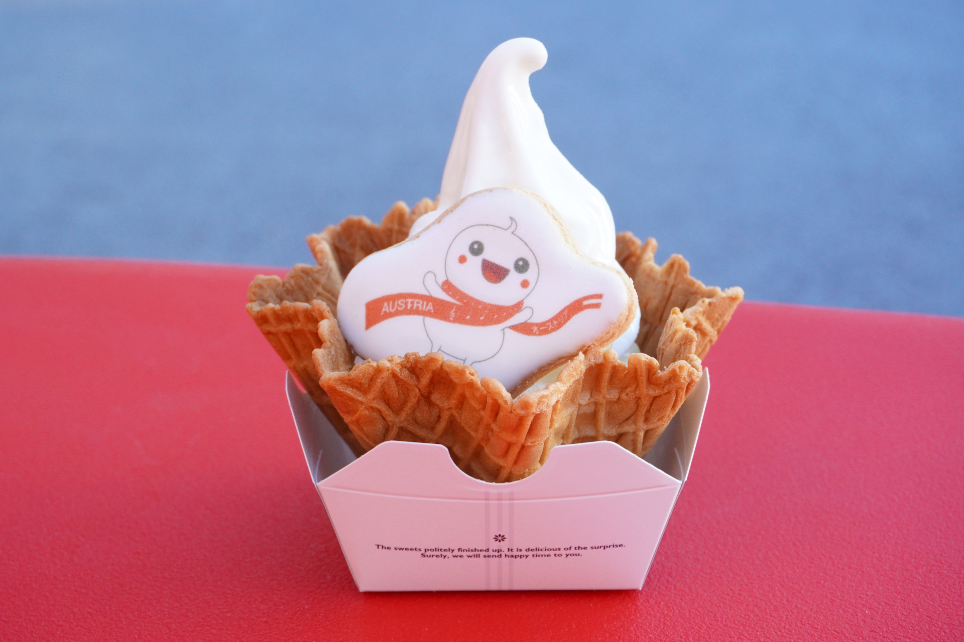 バニラ（オーガニックはちみつがけ）。大きなワッフルコーンに盛られ、仕上げにたっぷりのオーガニックはちみつと、赤白赤ちゃんのアイシングクッキーが添えられる