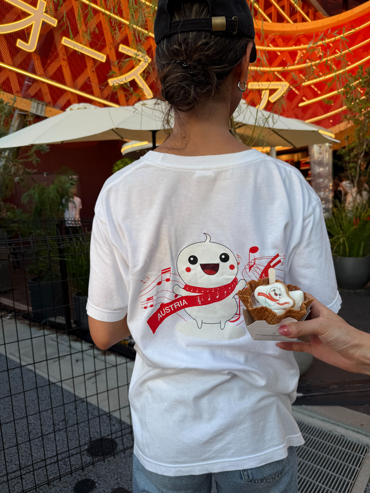ひそかに人気のオーストリアパビリオンキャラクター「赤白赤ちゃん」。併設のショップで販売しているTシャツは8月末に再入荷とのこと