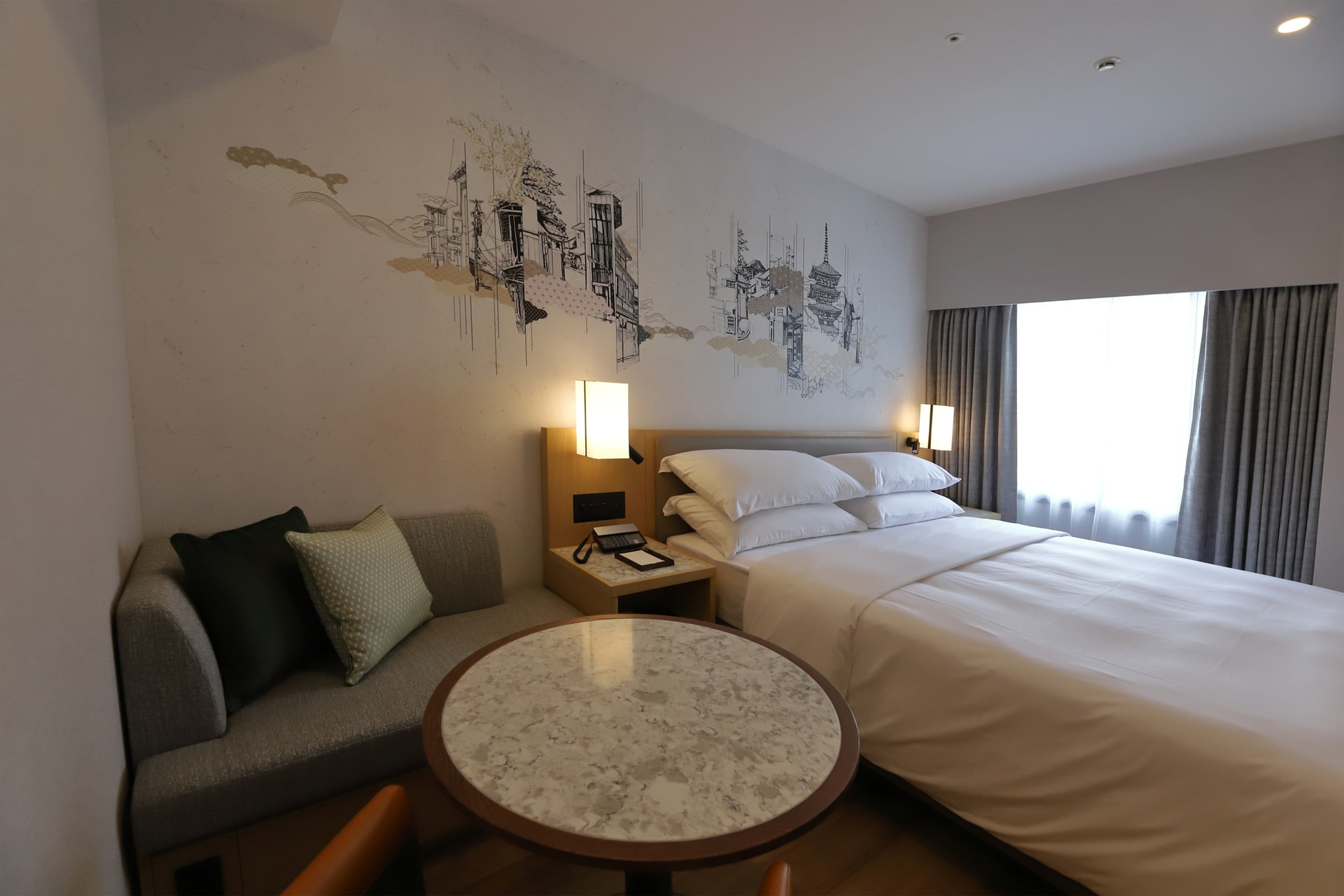 ソファ、テーブル、チェア。壁面の京都の街並みもシンプルな色使いで空間にマッチしている